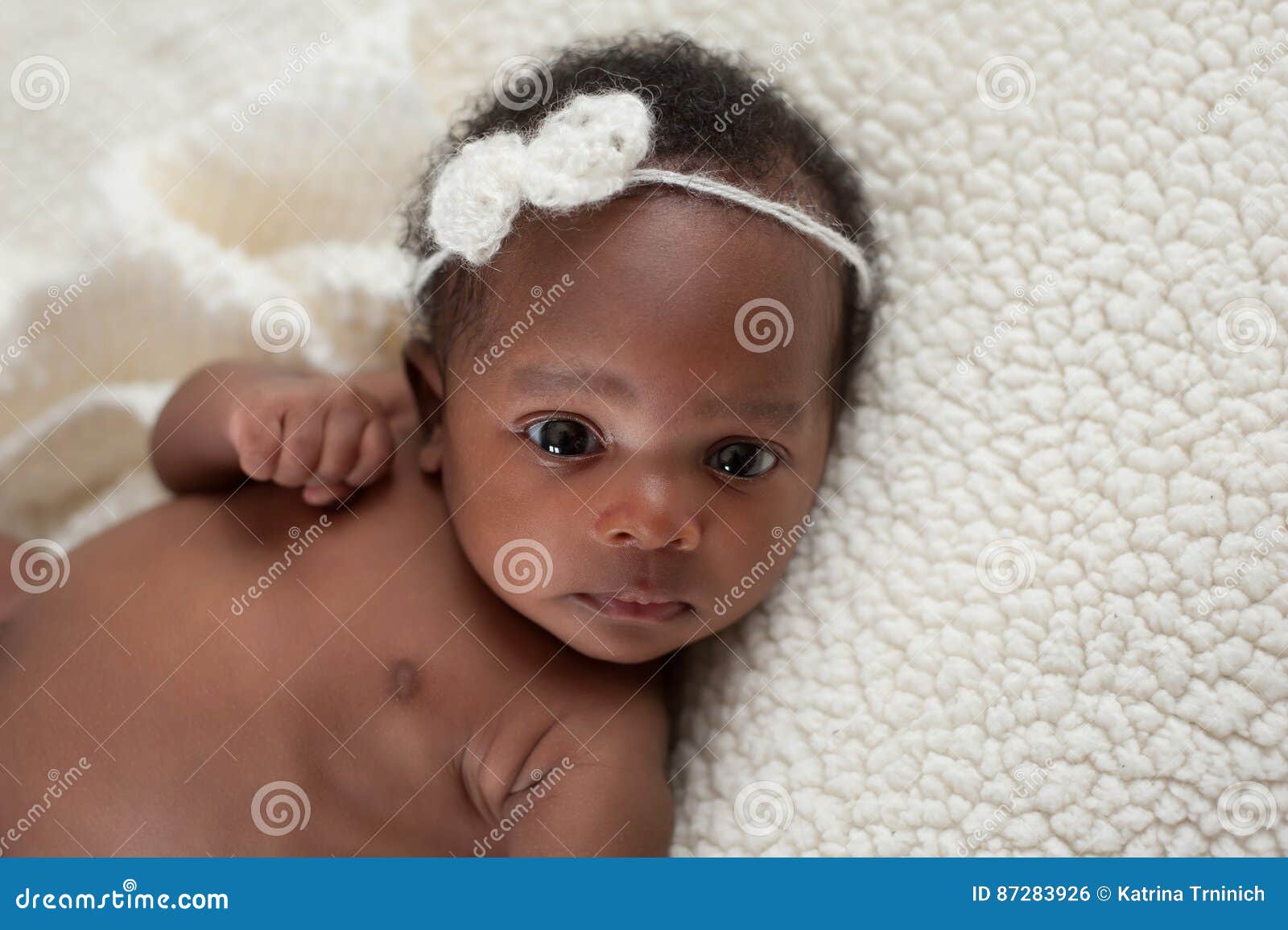 newborn baby girl on faux sheepskin blanket