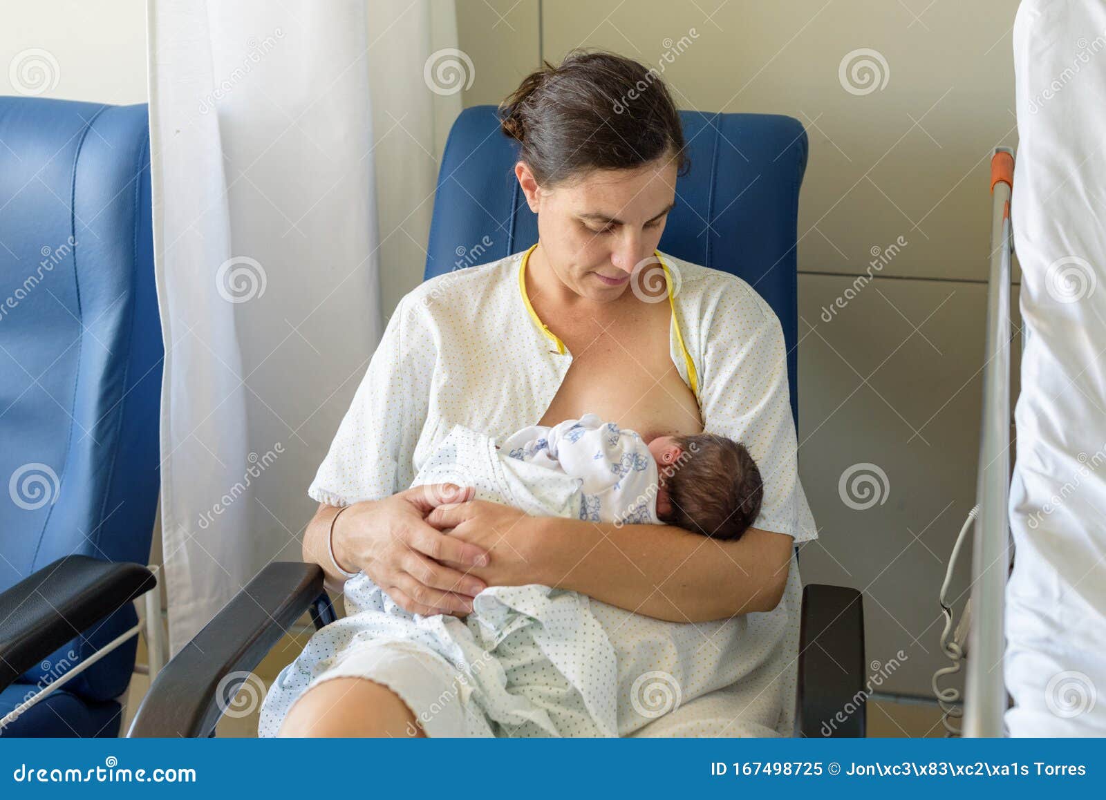 newborn baby in mother`s arms in