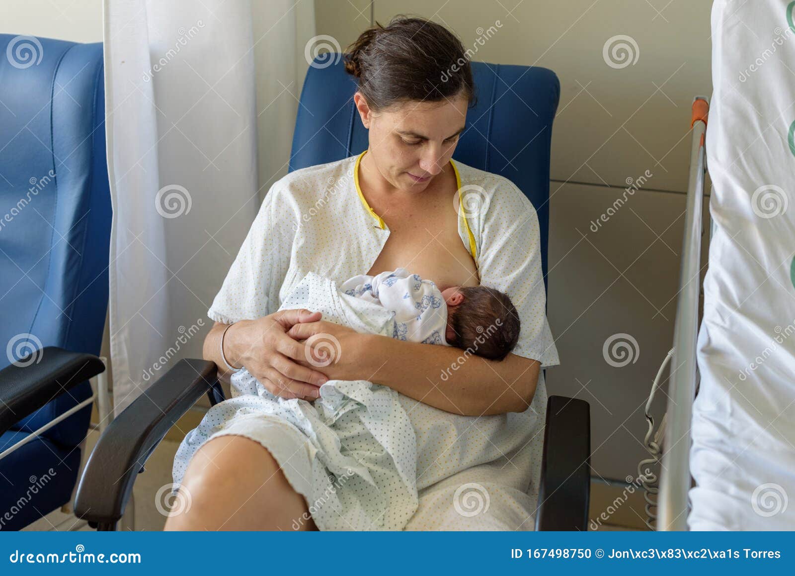 newborn baby in mother`s arms in