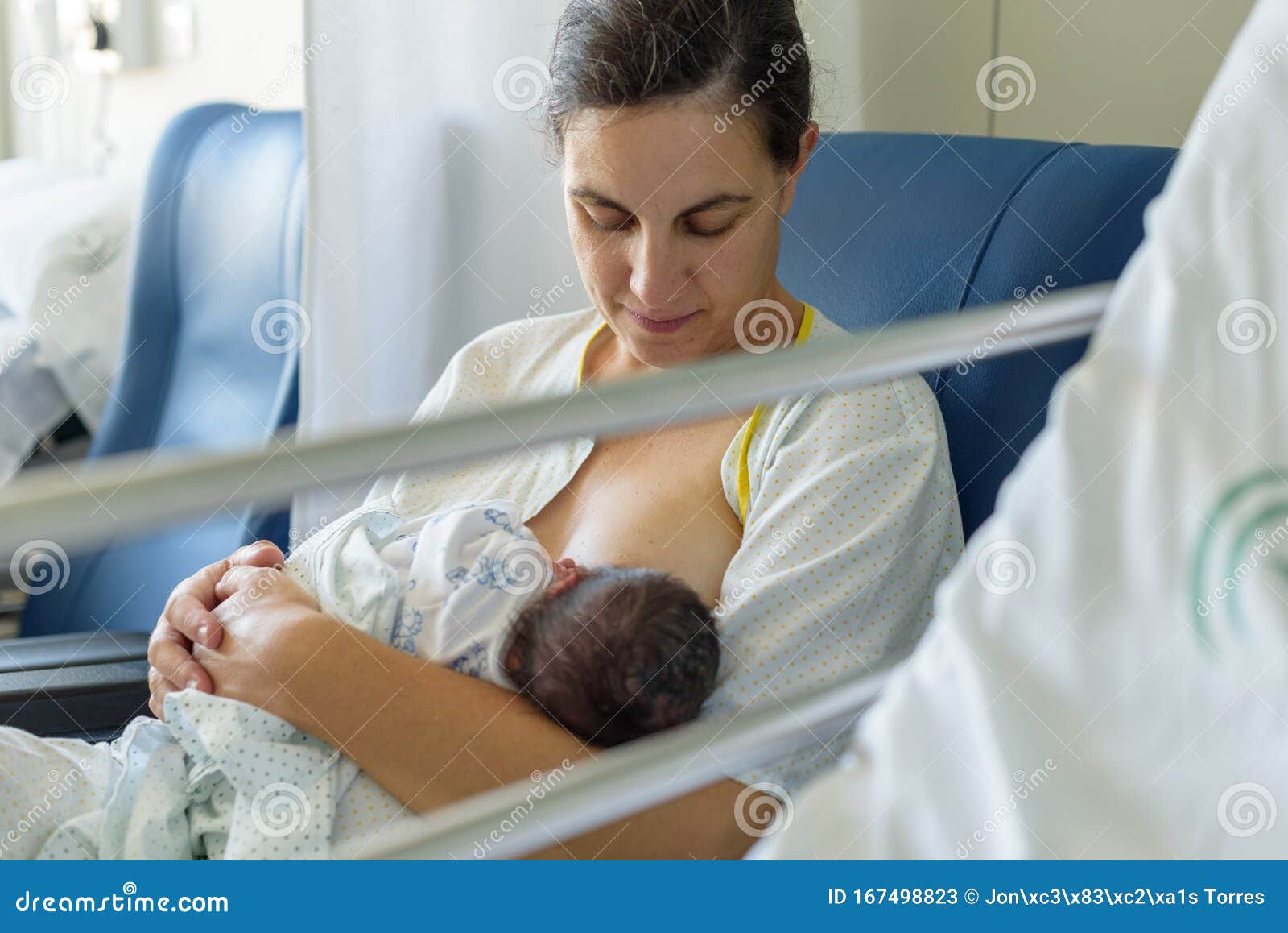 newborn baby in mother`s arms in