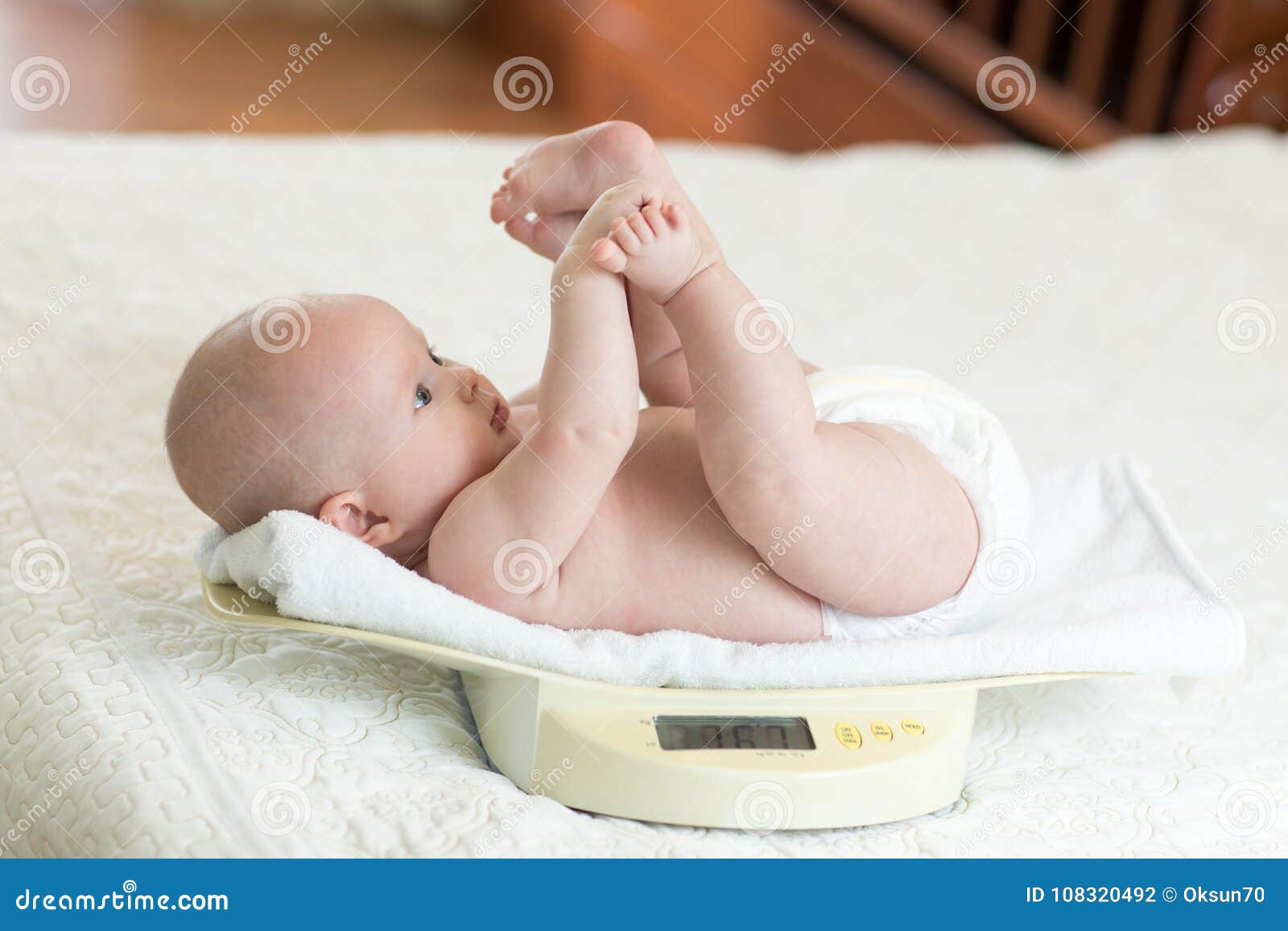 Weighing a newborn / new born baby with weighing scales / scale soon after  childbirth / giving birth in an NHS hospital Stock Photo - Alamy