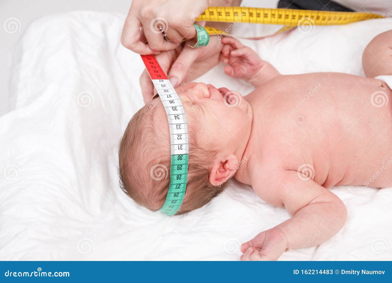 Newborn Medical Exam - Doctor Checking Head Size with a