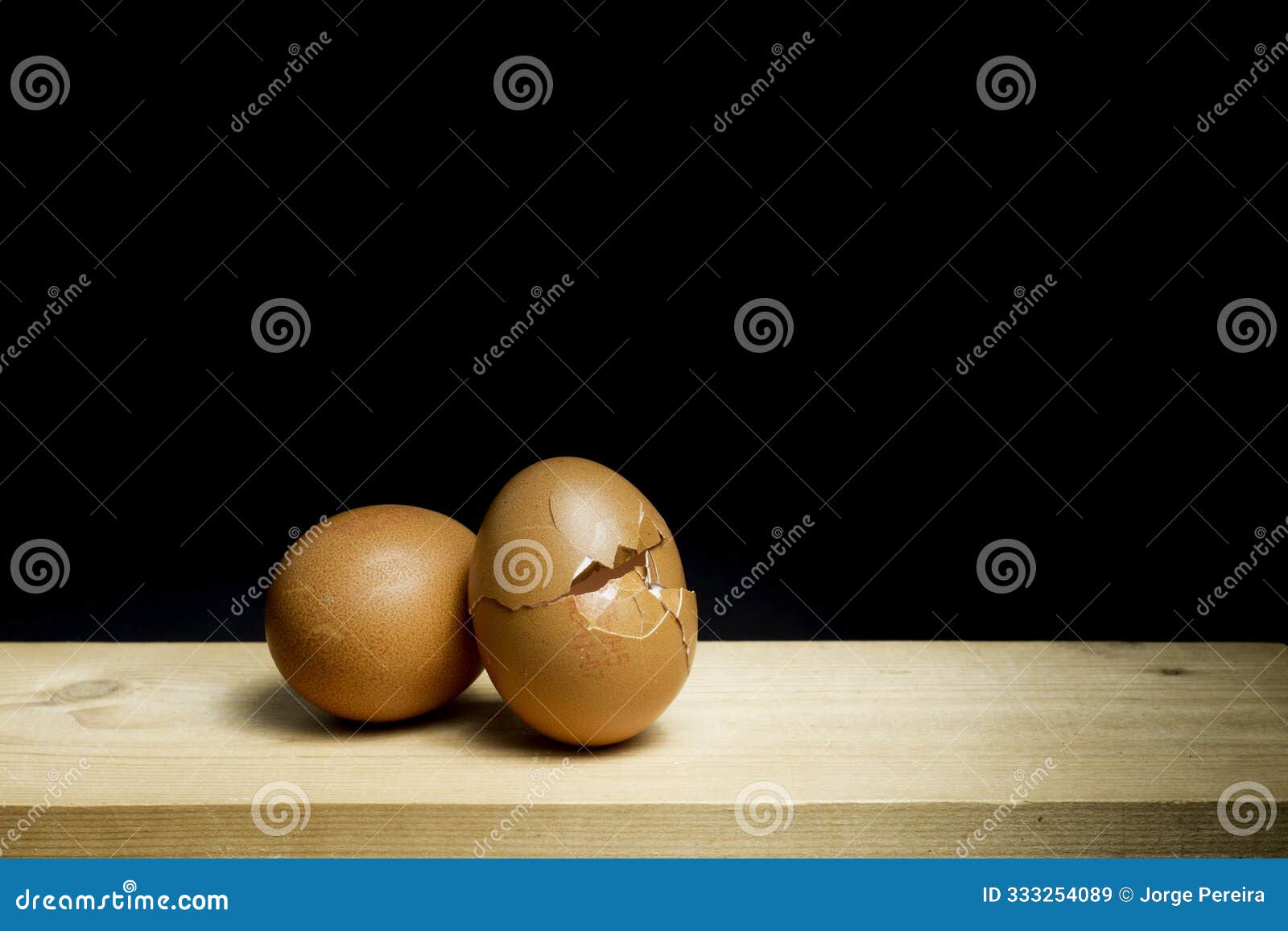 next egg to break - two eggs on table against black background