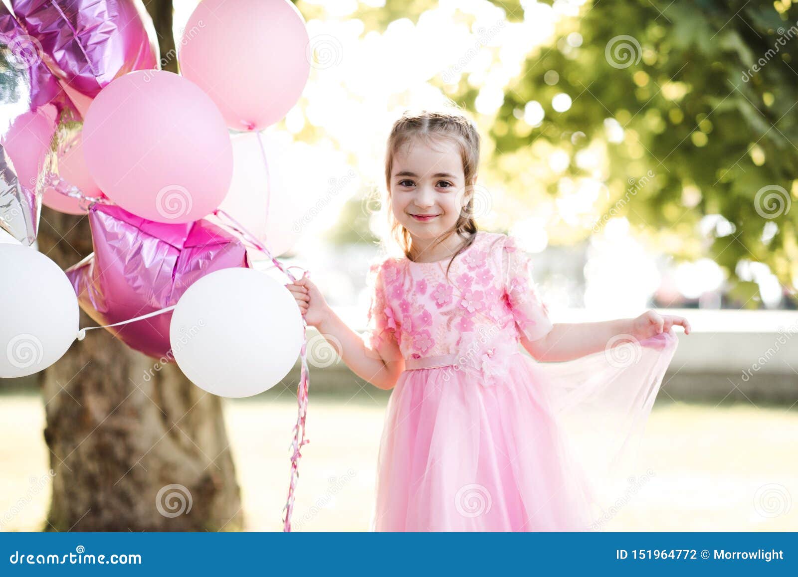 Una Niña De 4 Año De Edad En Pie Y Mirando La Cámara Mientras Que Jugando  Con Algunos Globos Multicolores. Fotos, retratos, imágenes y fotografía de  archivo libres de derecho. Image 8060540