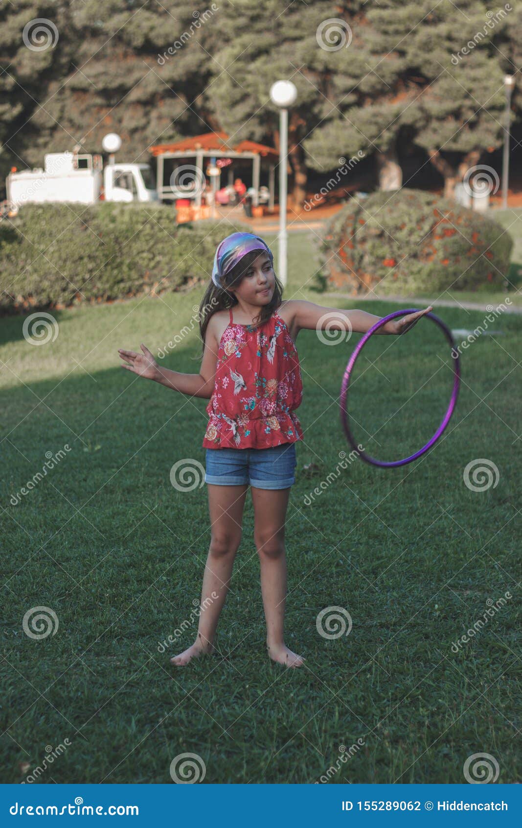 Una niña deportiva haciendo ejercicio con hula hoop sobre el parque