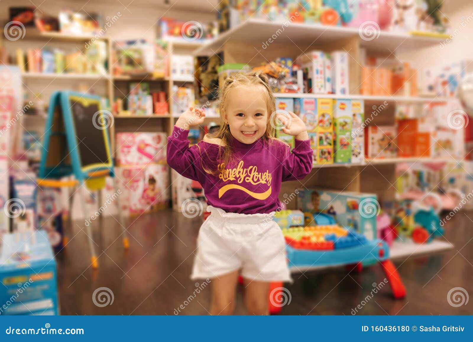 Niña Feliz Caminando En Una Tienda De Juguetes. Una Chica Linda Elige El Juguete. Hembra Adorable En El Centro Comercial Infantil Foto de archivo - Imagen de linda, hembra: 160436180