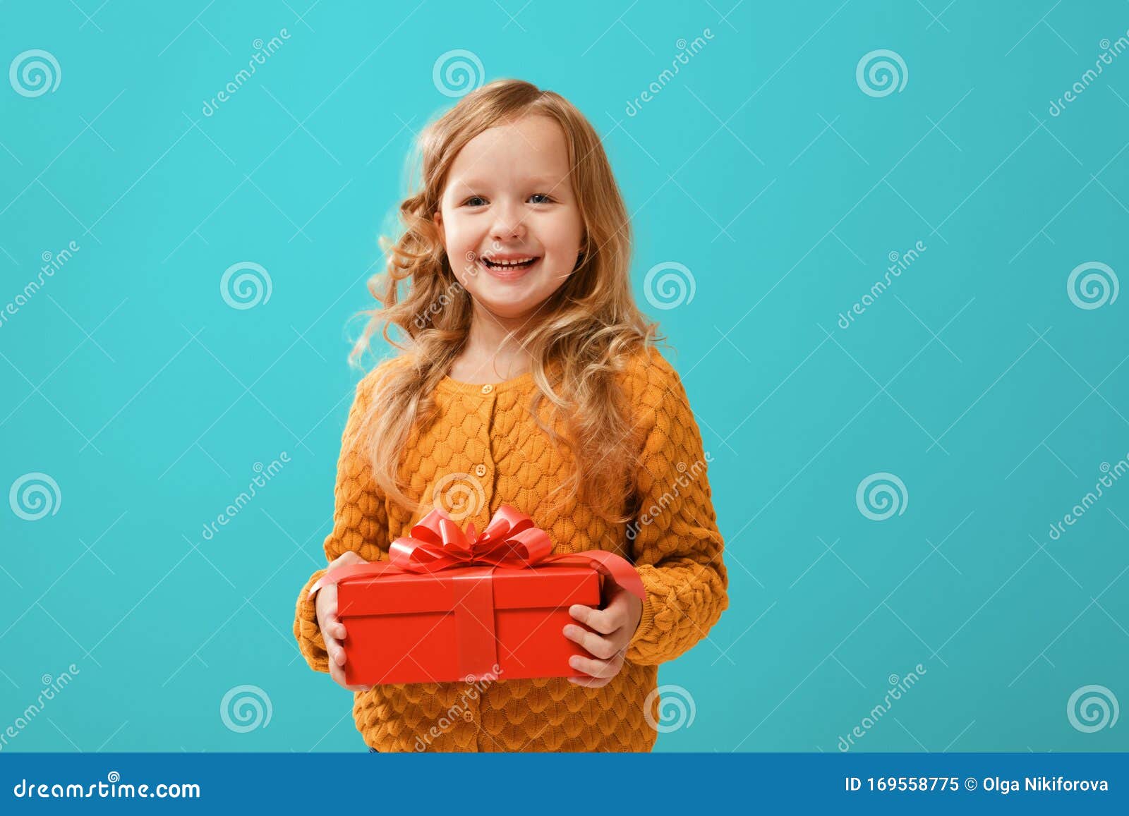 voltereta lila caloría Niña Feliz Con Un Abrigo De Punto De Mostaza Abriendo Una Caja Roja Con Un  Regalo Sobre Un Fondo Cian Imagen de archivo - Imagen de knitted, poco:  169558775