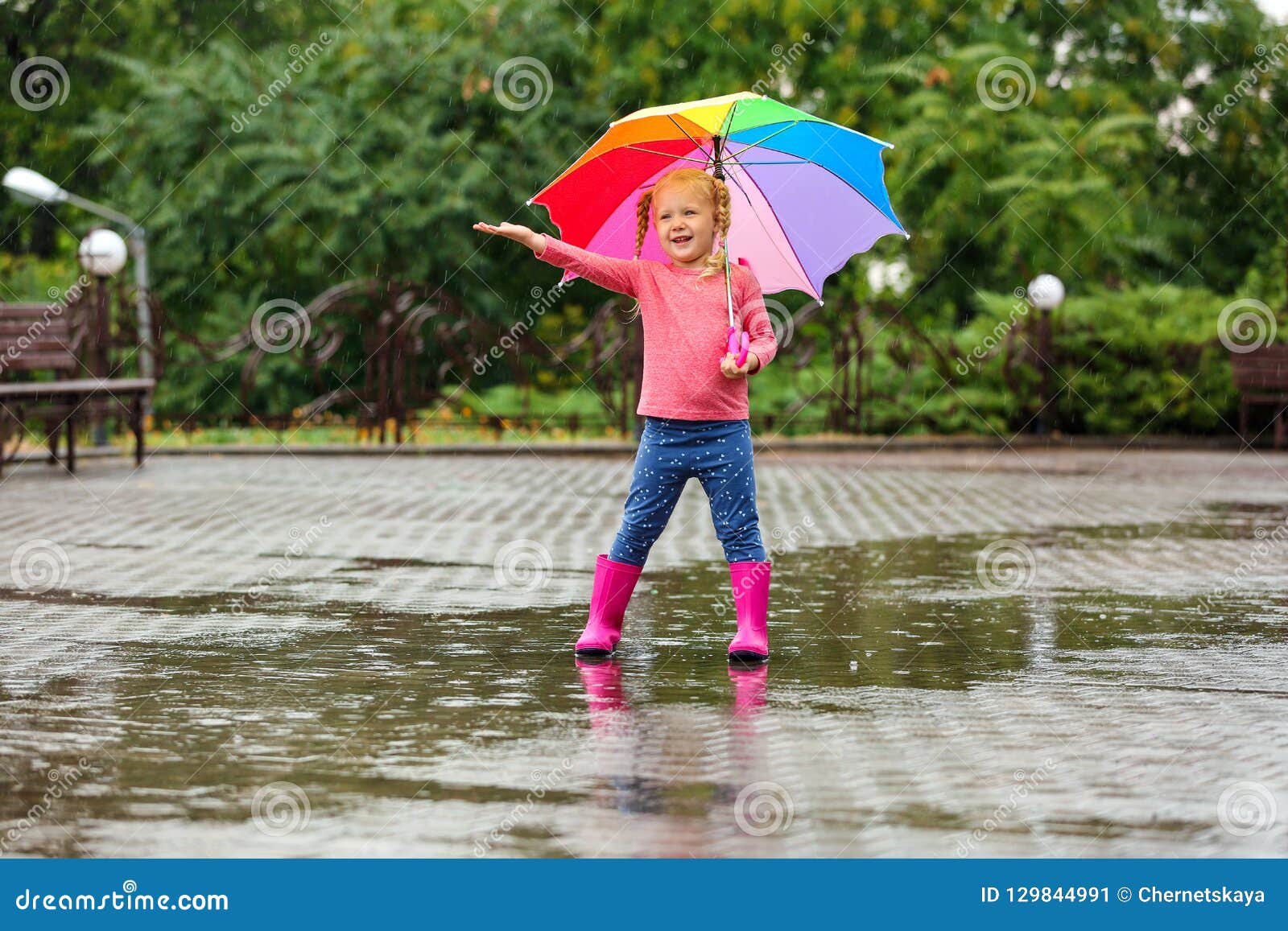 Niña Linda Con El Paraguas Brillante Debajo De La Lluvia Imagen de archivo - Imagen de arrancar, persona: