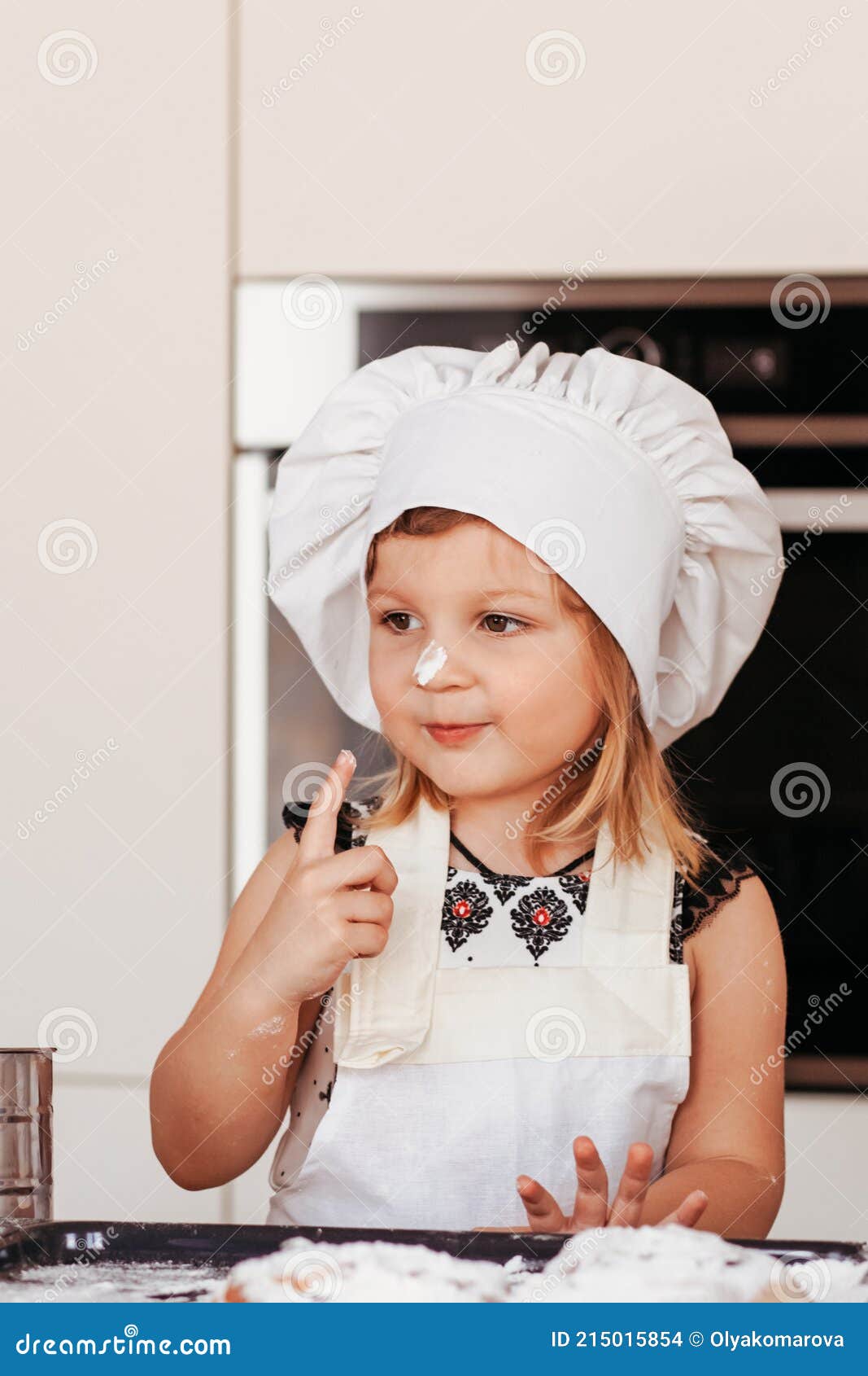 Niña Linda Juega Con Harina En La Cocina En Un Delantal Blanco Y Chefs  Sombrero Foto de archivo - Imagen de alimento, amasamiento: 215015854