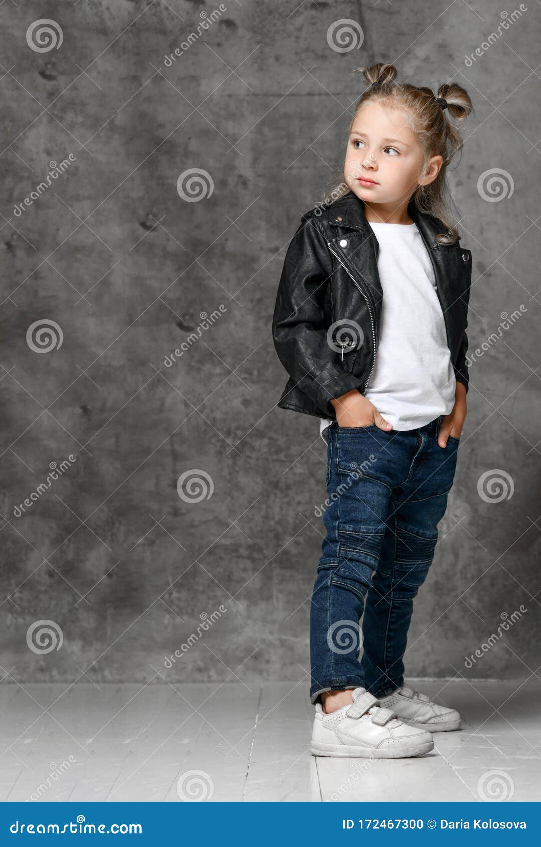 Niña Rubia Sonriente Con Elegante Chaqueta De Cuero Negro Estilo Rock, Jeans Azules Y Zapatillas Blancas De Pie Las Manos En de - Imagen de ropas, ocasional: 172467300