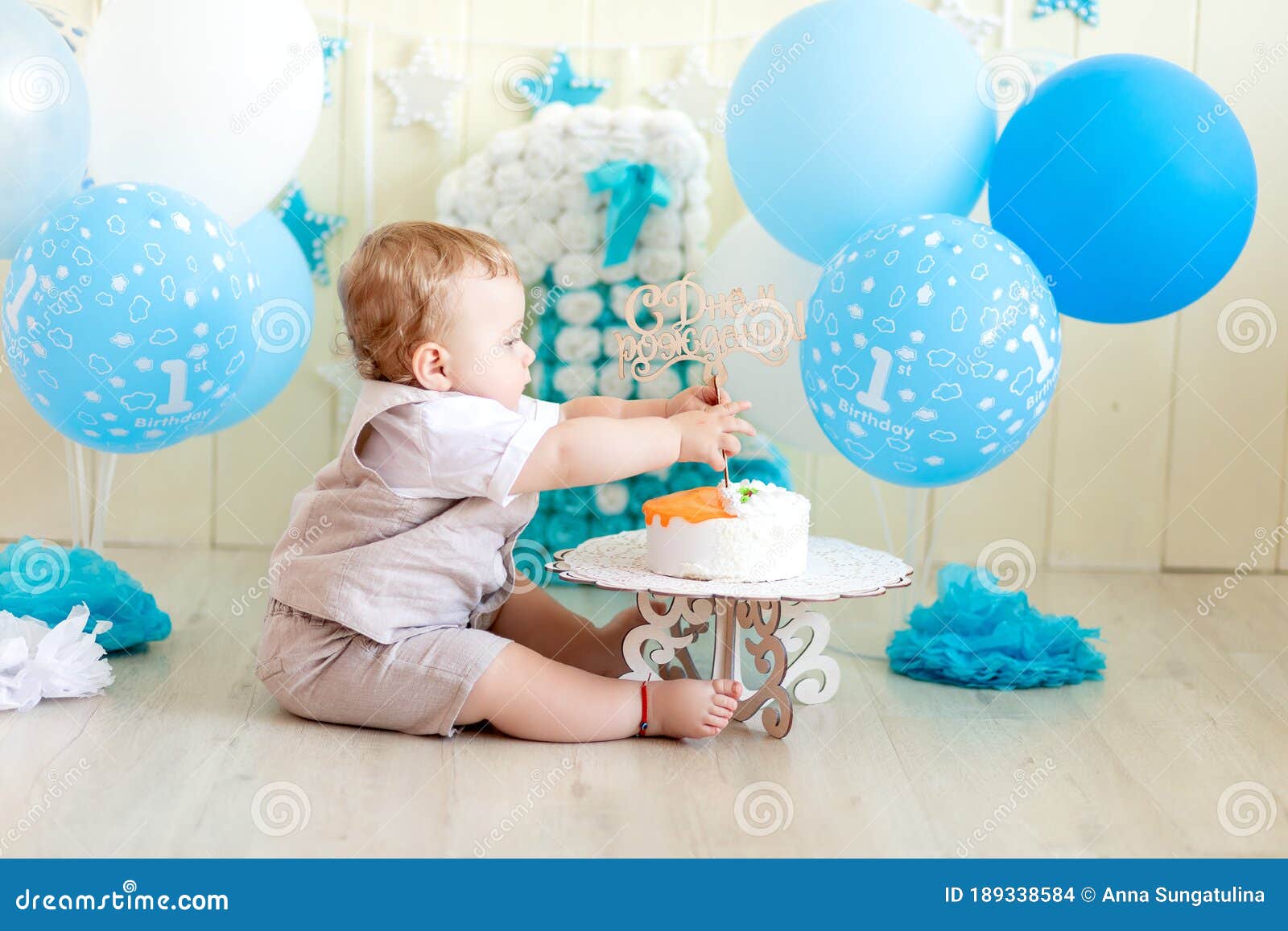 Bebé de 1 año en un estudio fotográfico con un pastel y globos