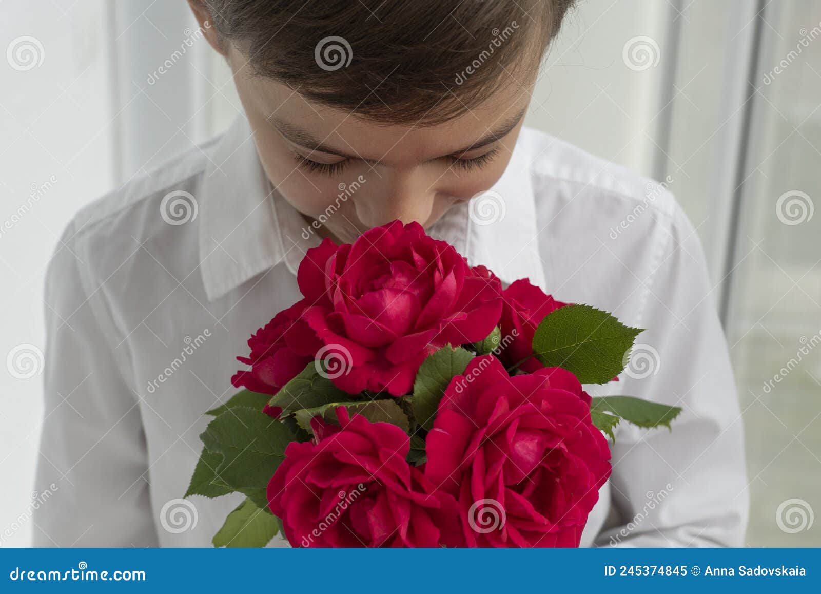 Niño Camisa Blanca Esconde Su Rostro En Un Ramo De Flores Rojas Con Imagen de archivo - Imagen de cabrito, hermoso: 245374845