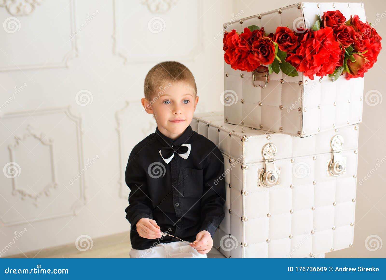 Niño De Camisa Negra Sentado De Cajas Con Rosas Rojas En La Habitación Con Interior Brillante Imagen de archivo - Imagen de oscuro, flor: 176736609