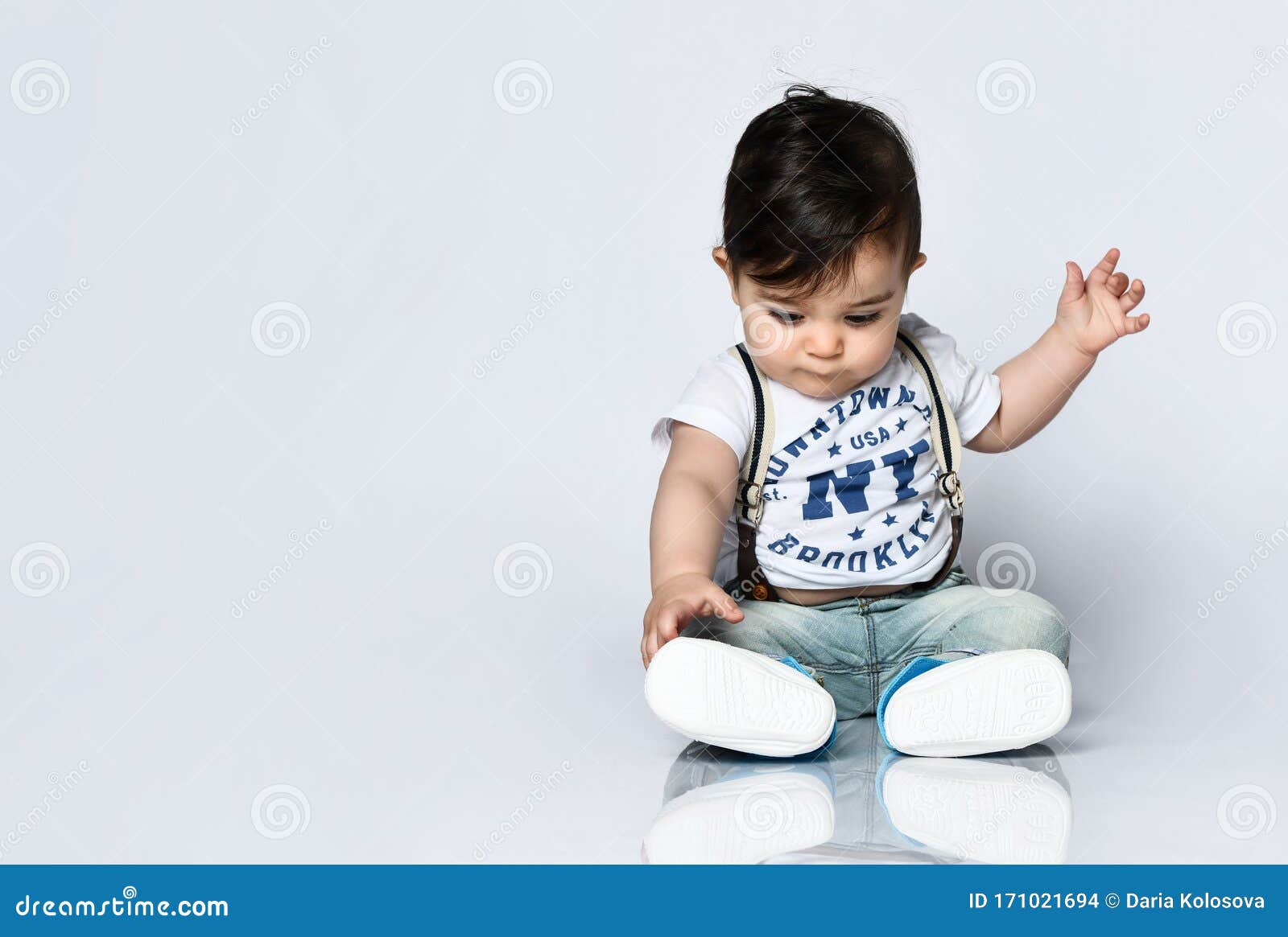 Antagonismo Industrial falso Niño En Camiseta Con Inscripciones, Vaqueros Con Tirantes Está Sentado En  El Suelo Aislado De Fondo Blanco Cerrar Foto de archivo - Imagen de copia,  vivero: 171021694