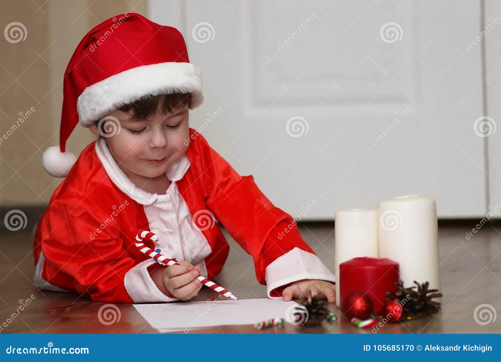 Niño En Un Traje De Santa Claus Que Escribe Una Letra Foto - Imagen de correo, tenencia: