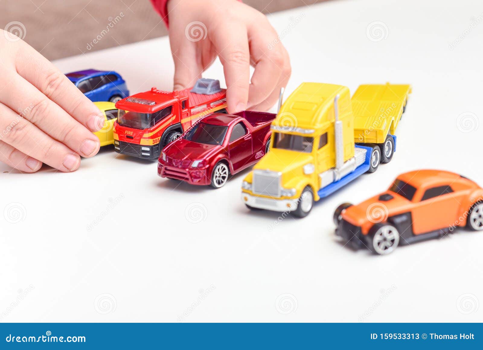 Niño Jugando El Niño Juega Con Los Coches De Juguete Cerca De Las Manos Imagen de archivo - Imagen de cerca, niño: 159533313