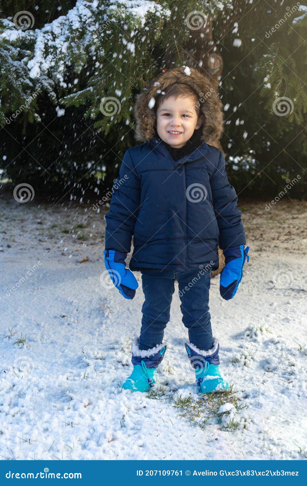 Niño Pequeño Con Botas De Abrigo Y Guantes Azules Sonriendo Mientras Los  Copos De Nieve Caen En Un Día De Invierno Imagen de archivo - Imagen de  felicidad, goce: 207109761