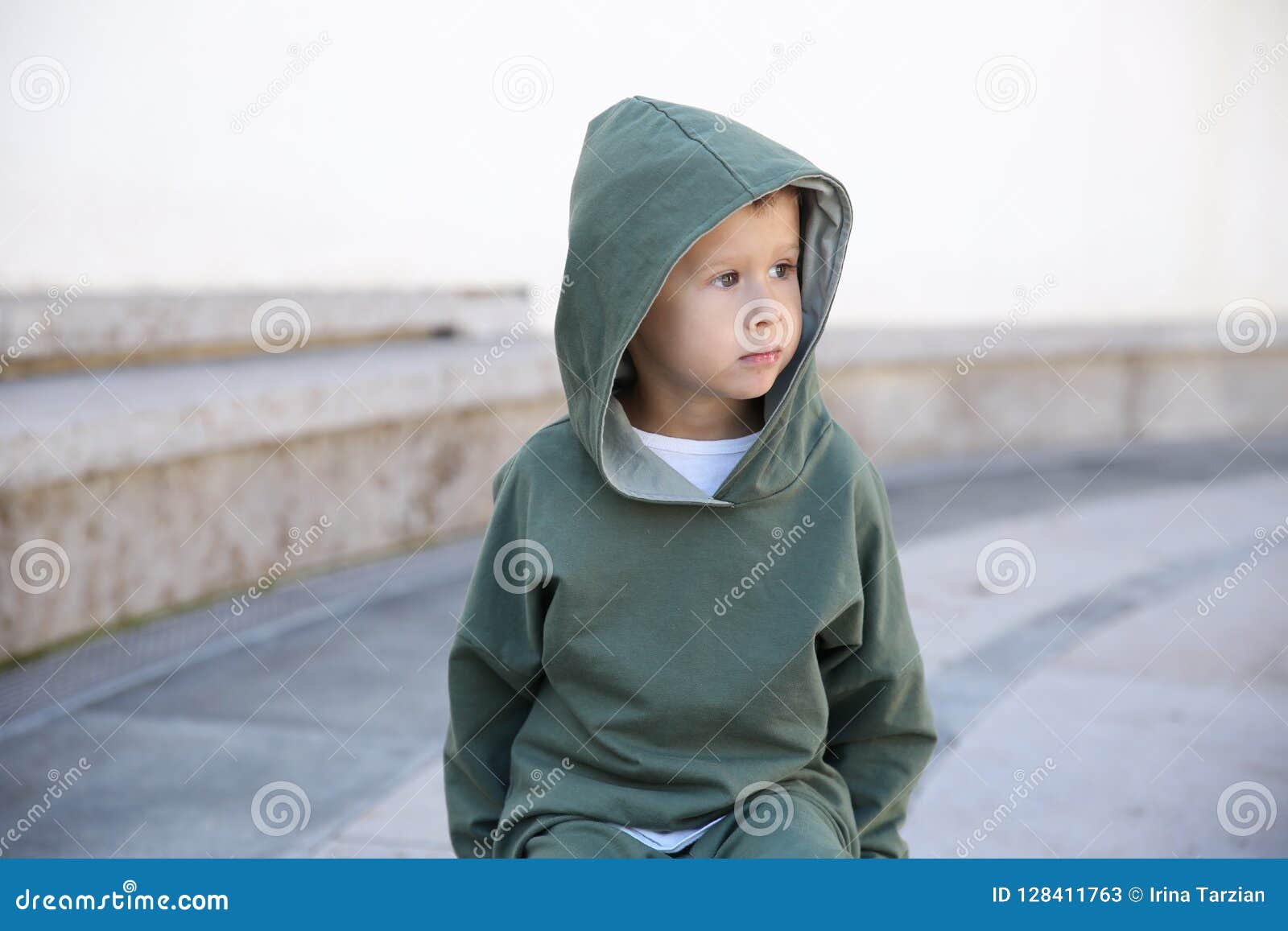 Niño Pequeño En Una Sudadera Con Capucha En Bola En Un Parque Imagen de archivo - Imagen de sentados, poco: 128411763