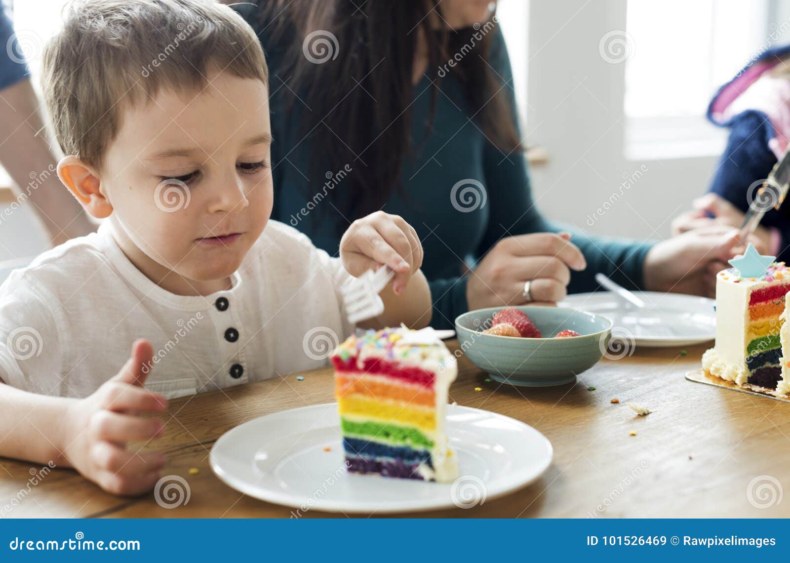 Niño Pequeño Que Come Una Torta Coloreada Arco Iris Imagen de archivo -  Imagen de paternidad, comer: 101526469