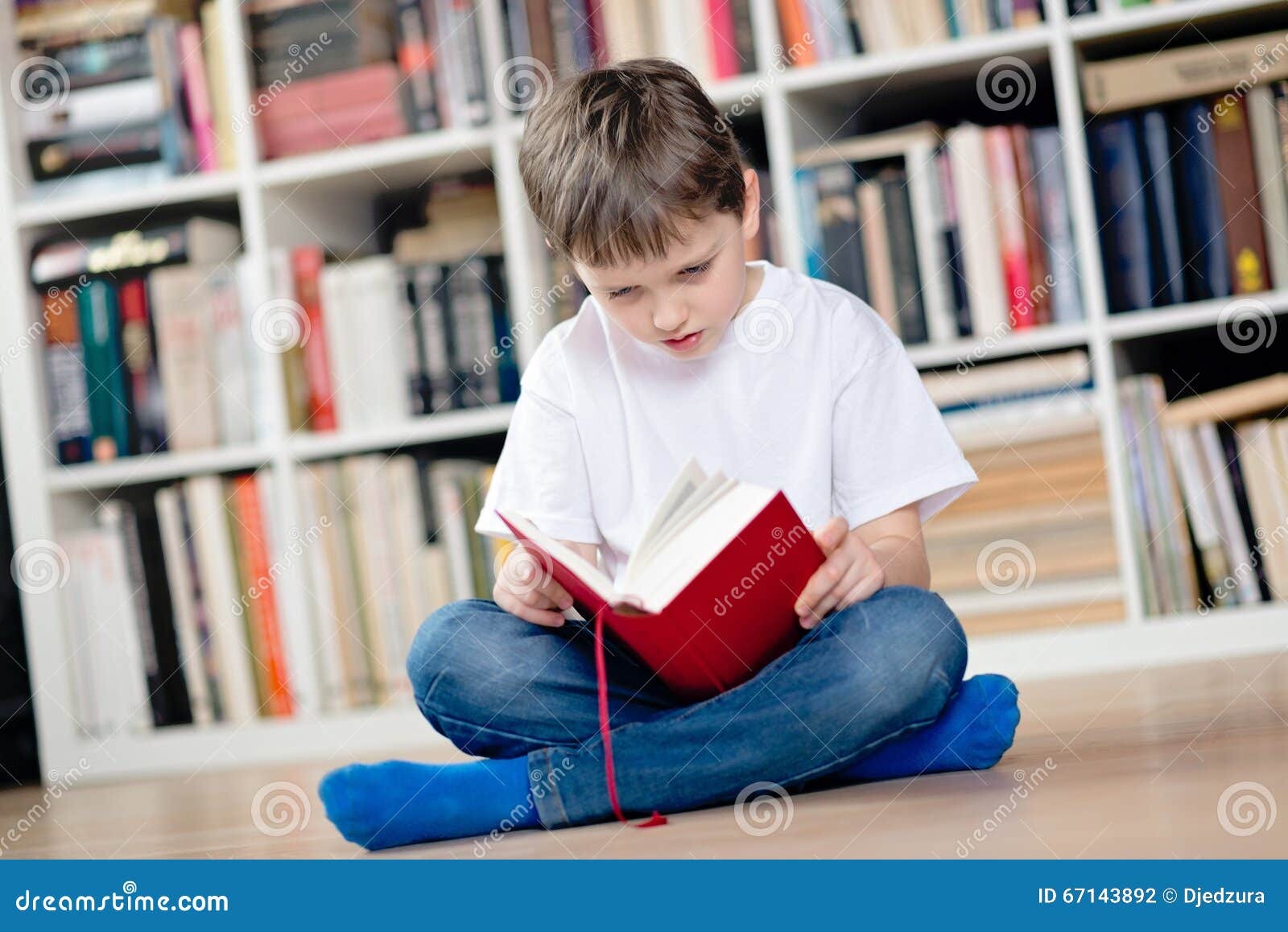 Niño Que Lee Un Libro Rojo En La Biblioteca Foto de archivo - Imagen de  sitio, inteligencia: 67143892