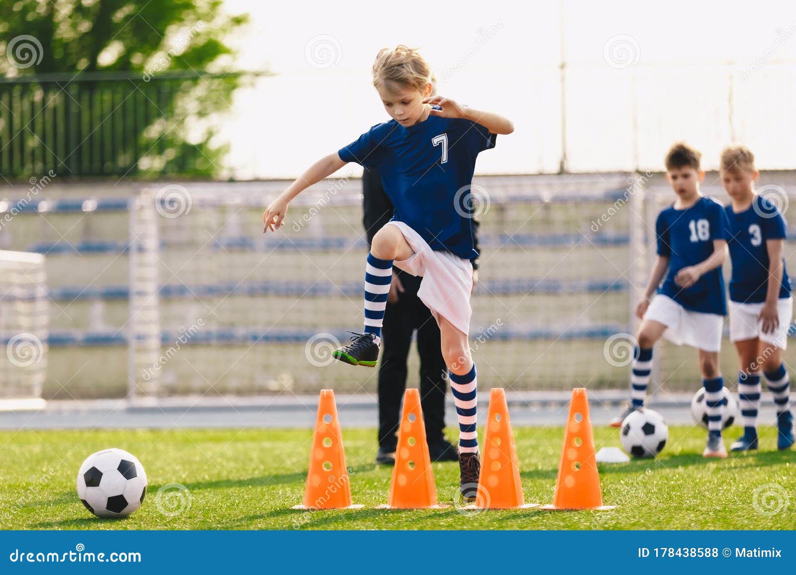Niño Saltando Sobre Conos De Fútbol En Campo De Entrenamiento De Fútbol  Foto de archivo - Imagen de club, muchacho: 178438588