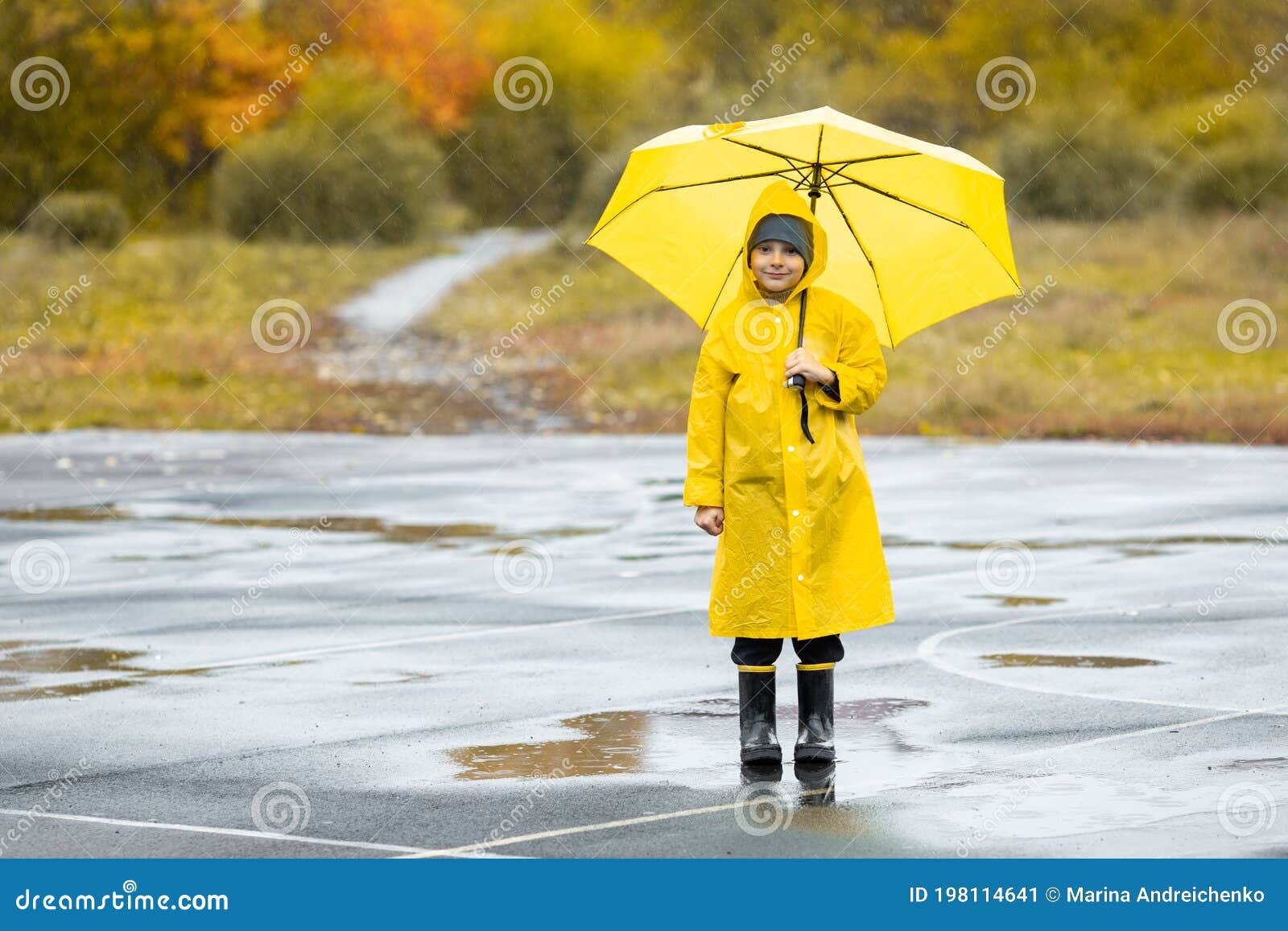 Niño Vestido Con Capa Impermeable Amarilla Y Botas De Goma Parado En Un  Charco Al Aire Libre En La Lluvia En Otoño Imagen de archivo - Imagen de  libertad, lluvia: 198114641