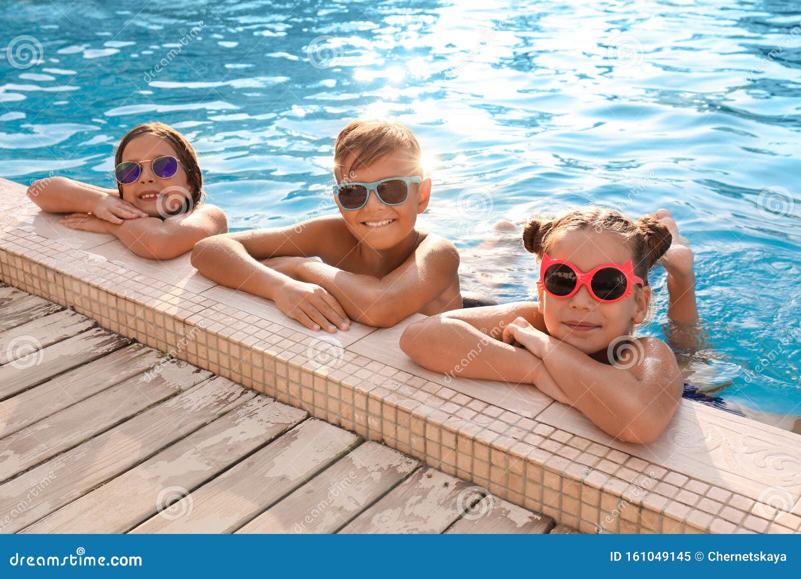 Niños Felices Con Gafas De Sol En La Piscina Imagen de archivo