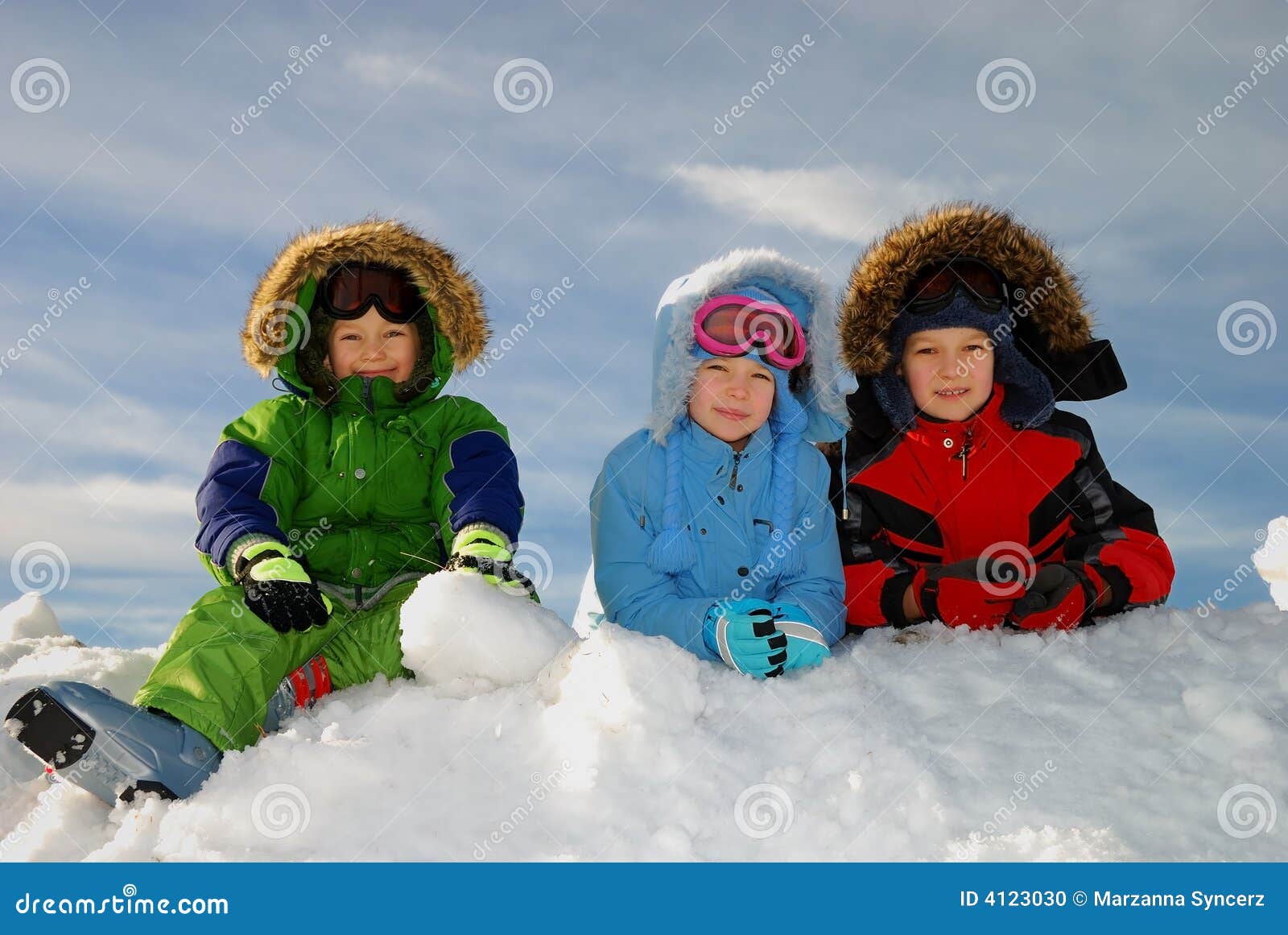 Niños felices con ropa de invierno en la nieve.