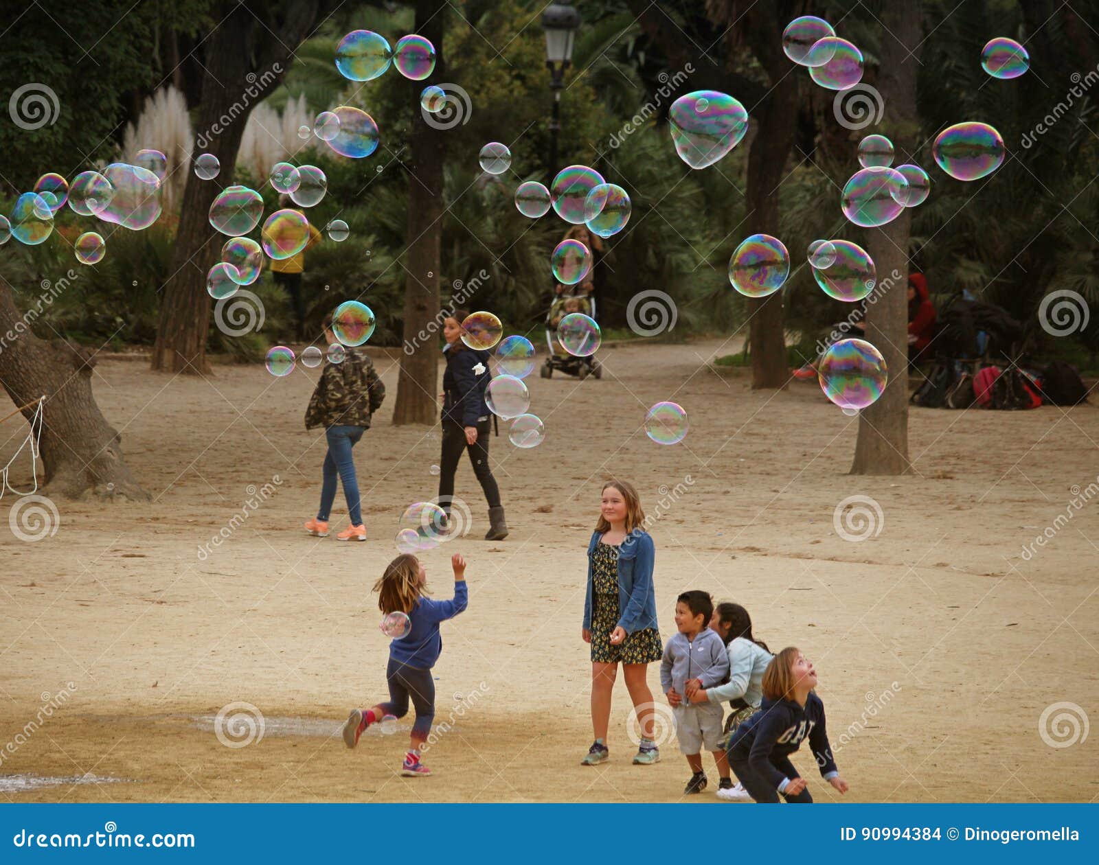 Niños jugando en el parque con pompas de jabón Stock Photo