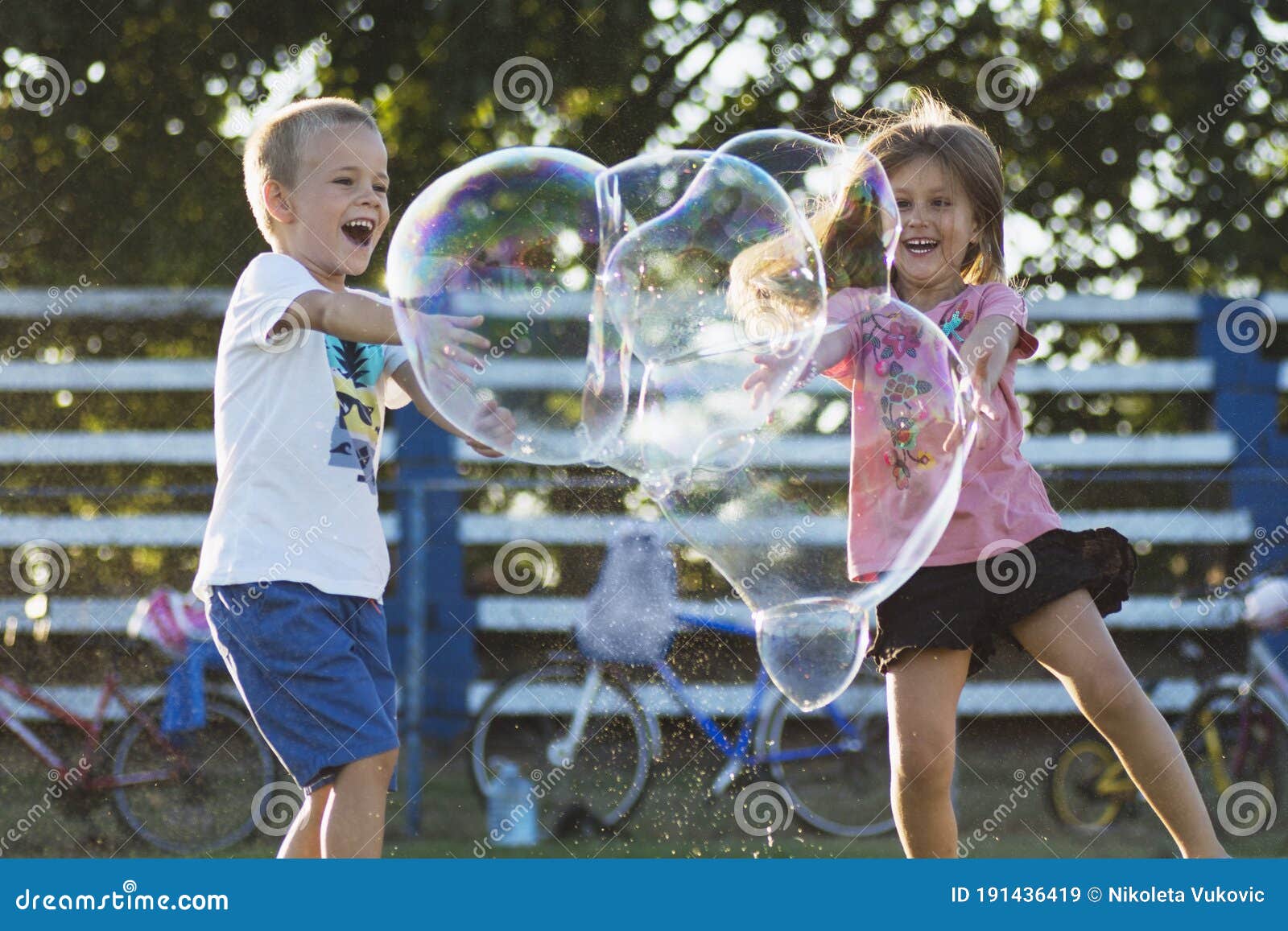 Niños jugando pompas de jabón al aire libre