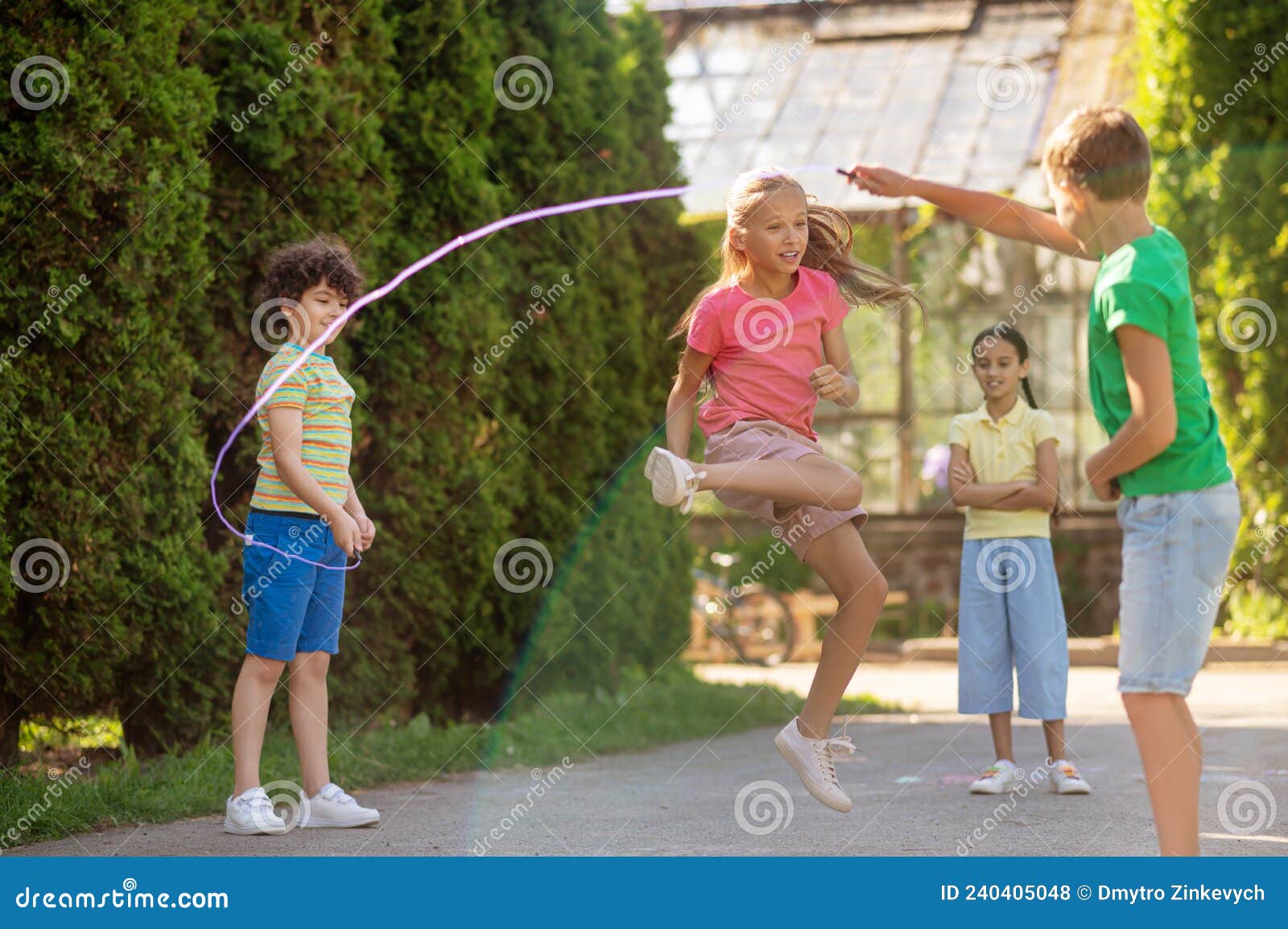 Niños Sosteniendo Una Cuerda De Saltar Y Niñas Saltando Foto de archivo -  Imagen de enérgio, muchacho: 240405048