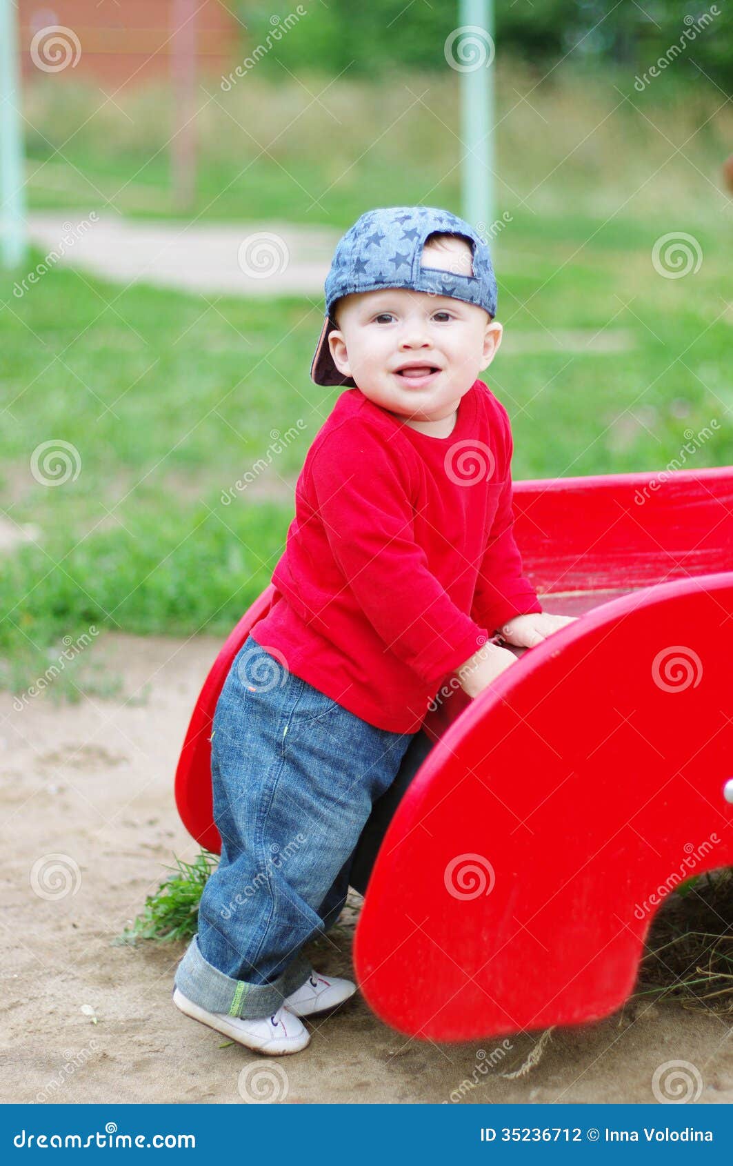 Nice Baby Boy Age of 10 Months on Playground in Summer Stock Photo