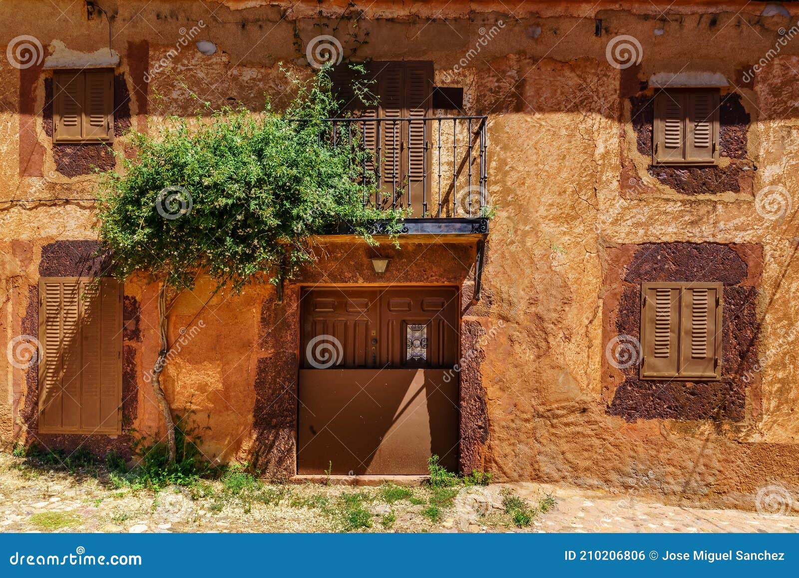 nice facade of stone houses with colorful plants and flowers at the entrance. spain