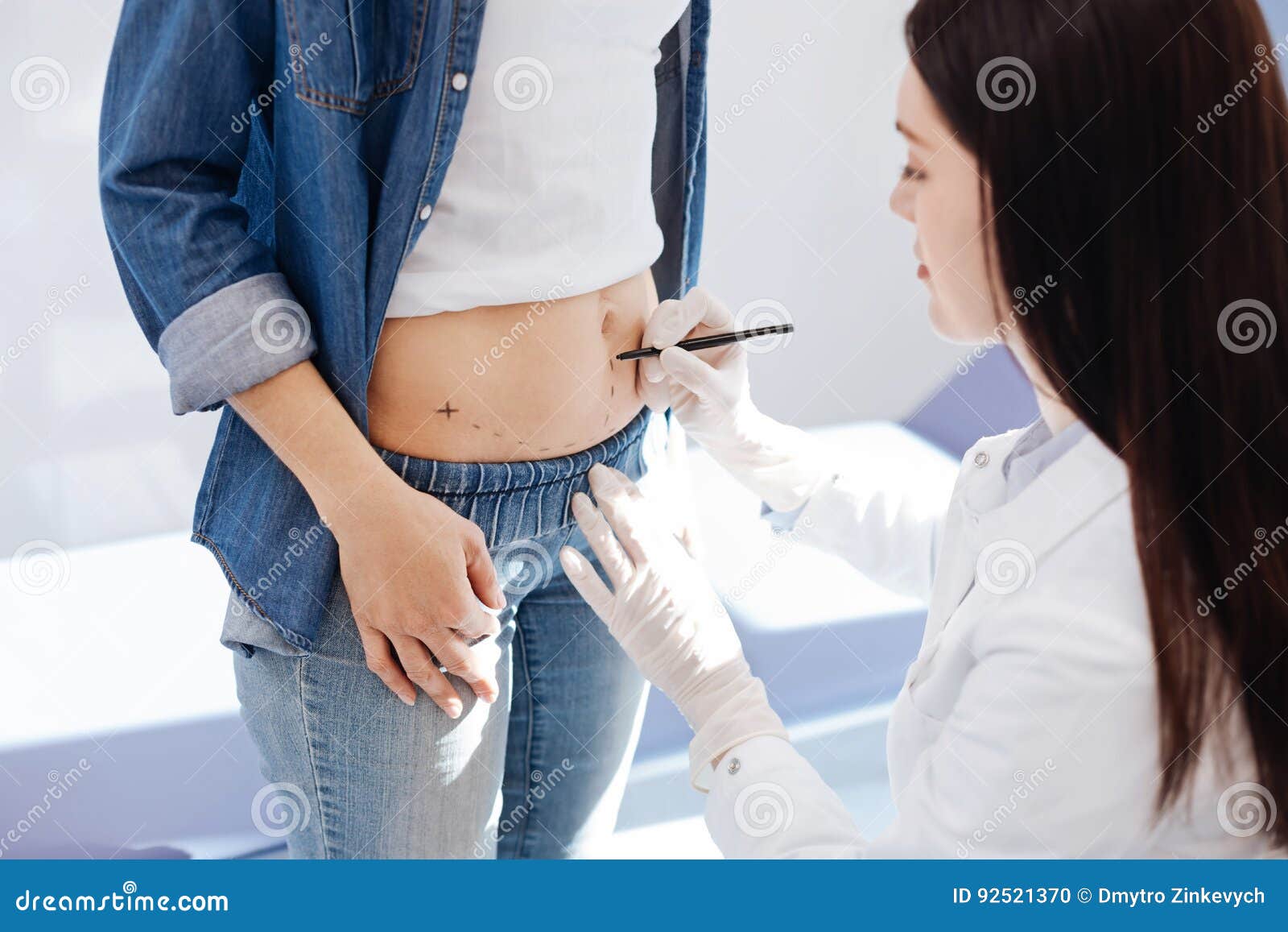 Nice Plastic Surgeon Looking at Her Patients Stomach Stock Photo
