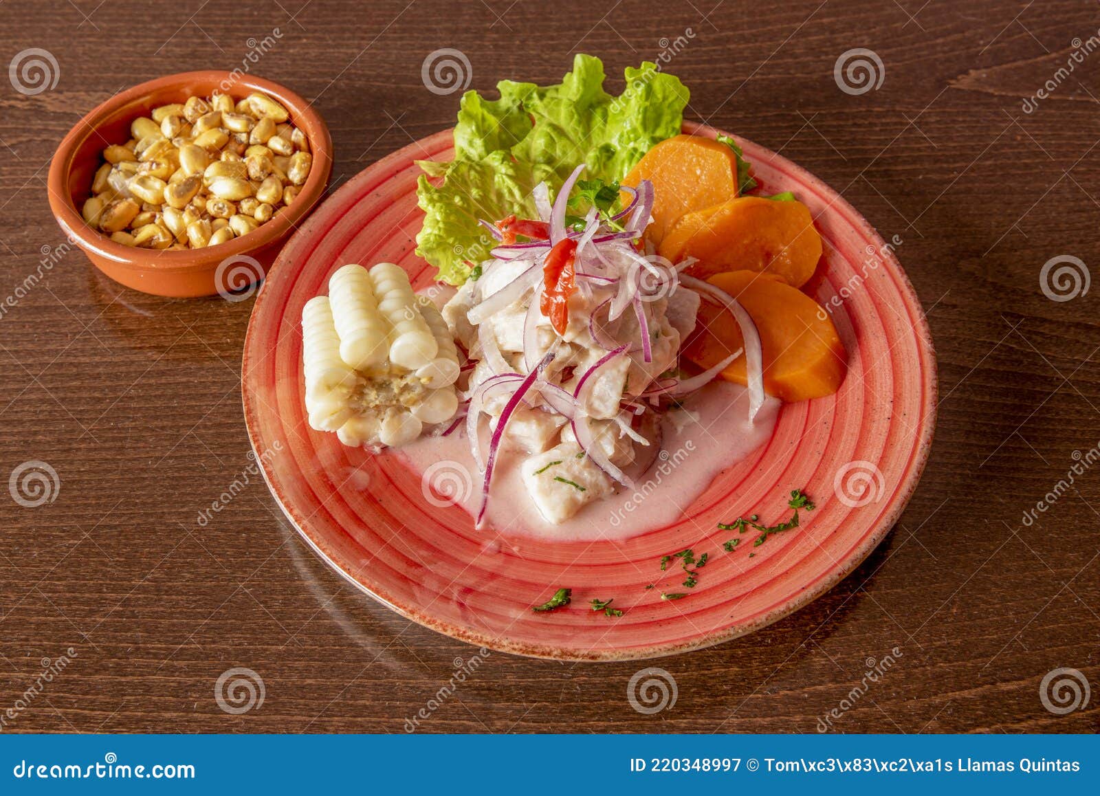 nice red plate with peruvian-style fish ceviche with white corn, cancha and sweet potato slices