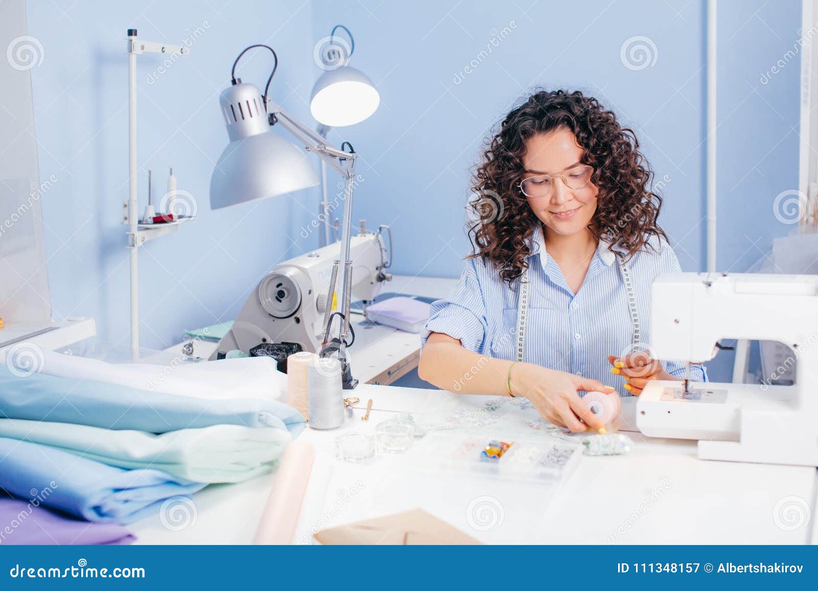 Nice Tailor is Sitting at Desk and Touching Pink Thread Stock Image