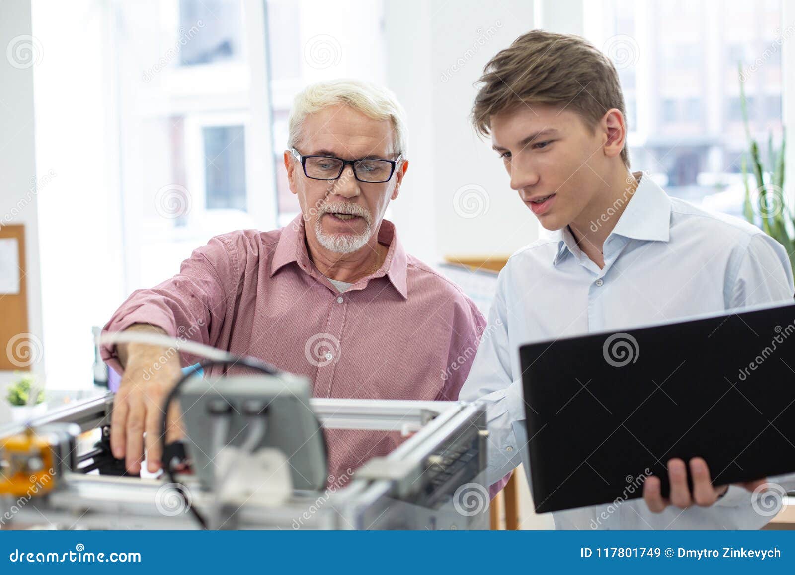 pleasant senior engineer teaching about 3d printer