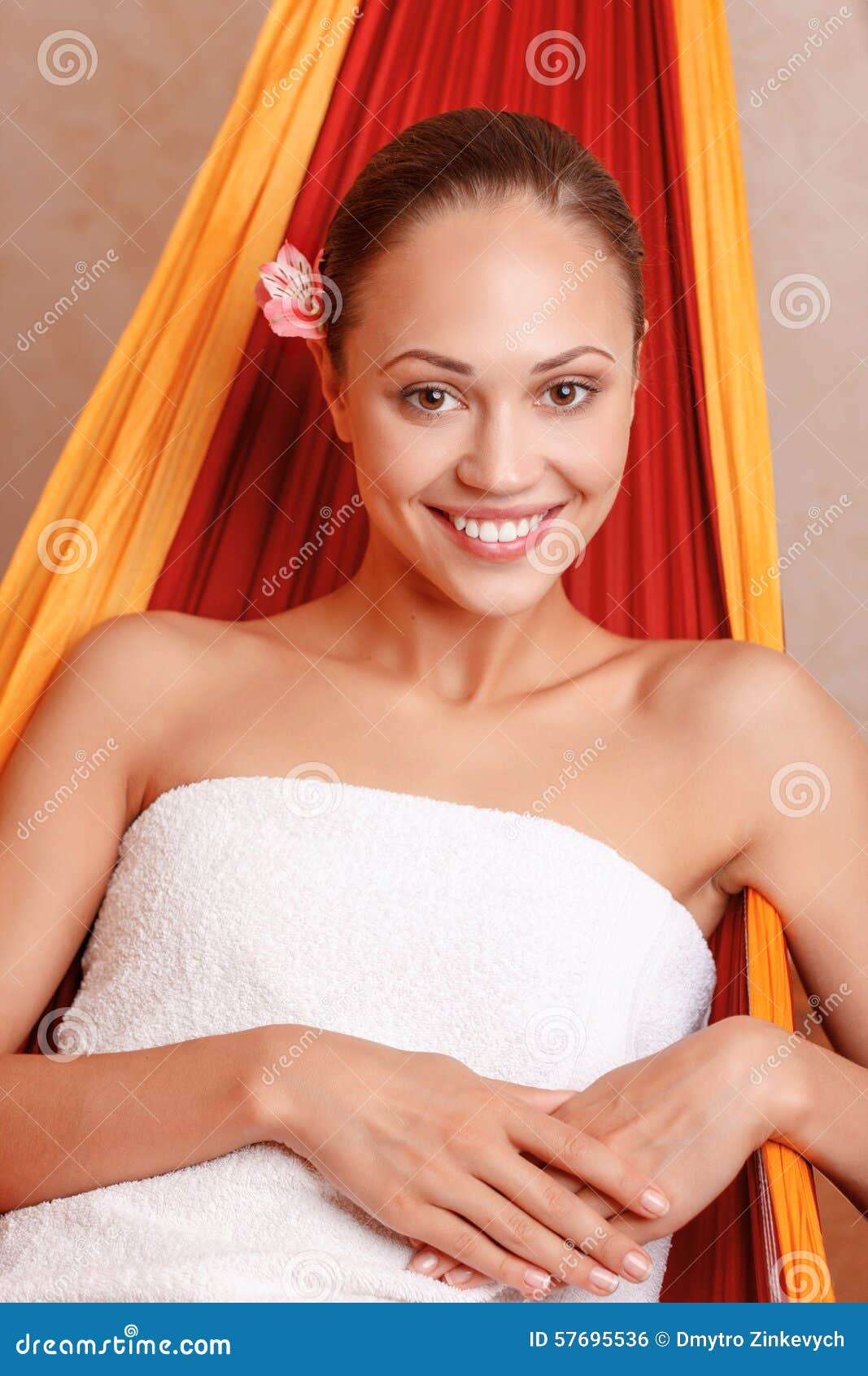 Nice woman sitting in spa salon. Just find your happiness. Nice blissful young woman keeping her hands together and smiling while sitting in spa salon