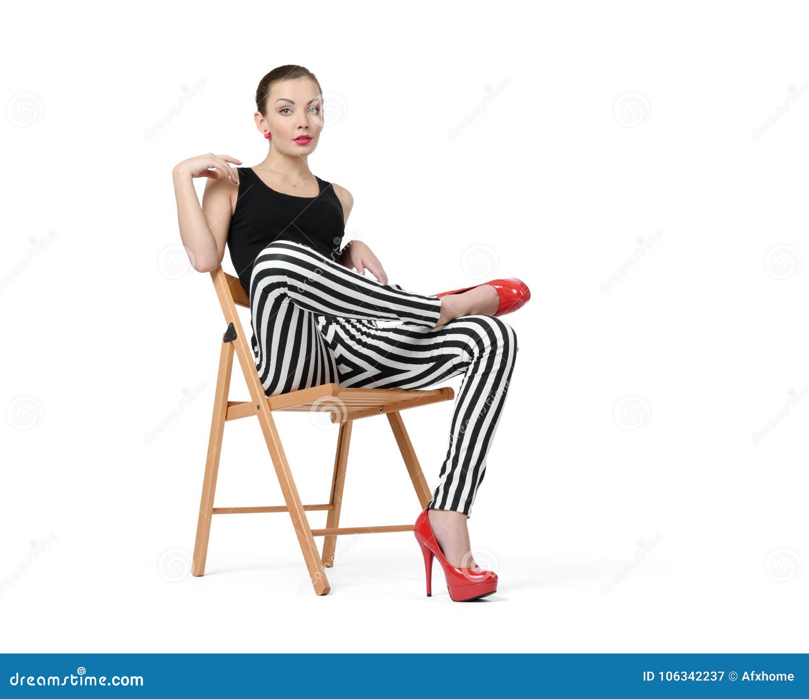 Nice Young Woman In Striped Pants And Red Heels Sitting In Chair