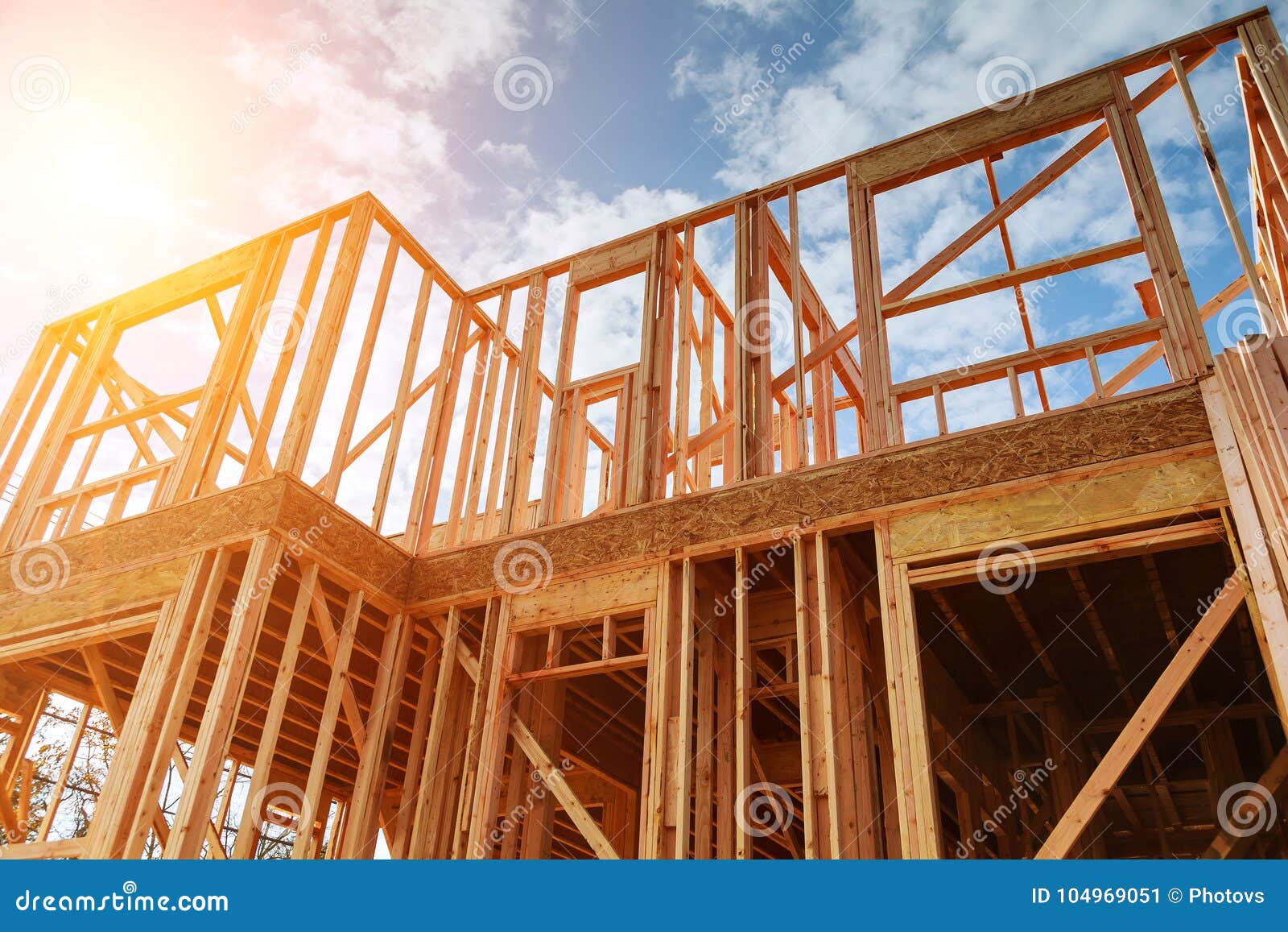 Nieuw woonbouwhuis frame tegen een blauwe hemel Dakwerkbouw Houten bouw, toren die van eiken stralen tegen bewolkte hemel wordt gemaakt