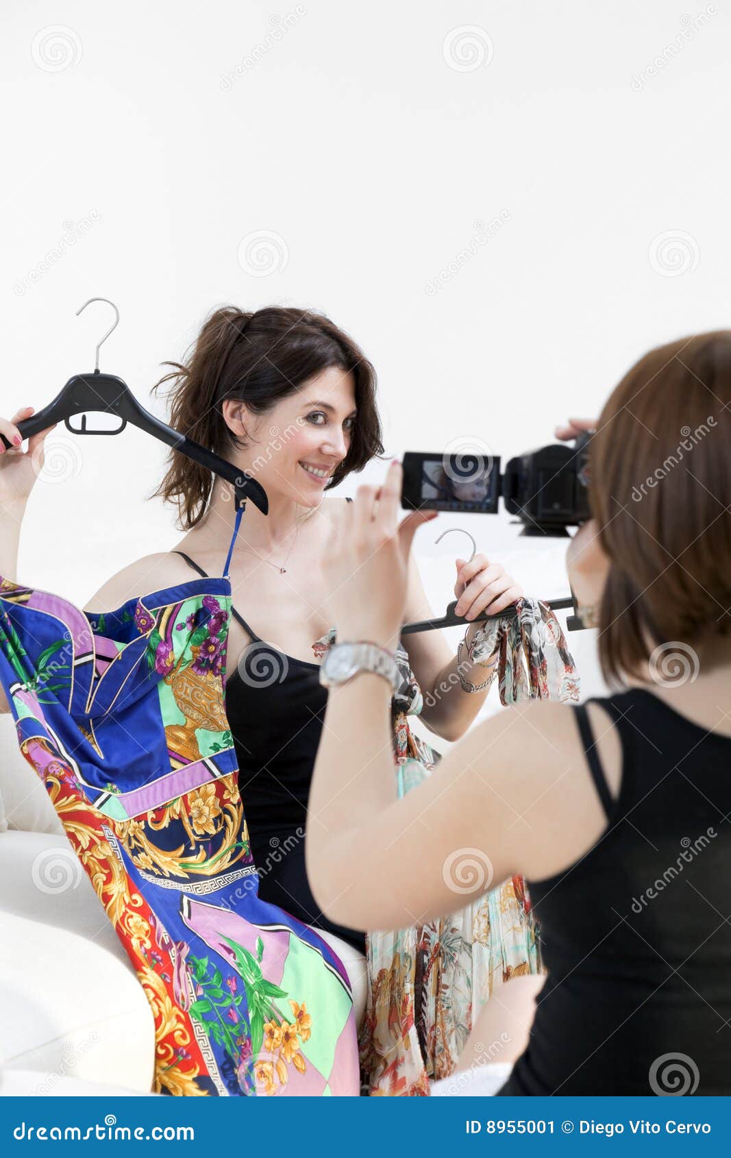 Twee vrouwen die nieuwe kleren tonen en pret met camcorder hebben