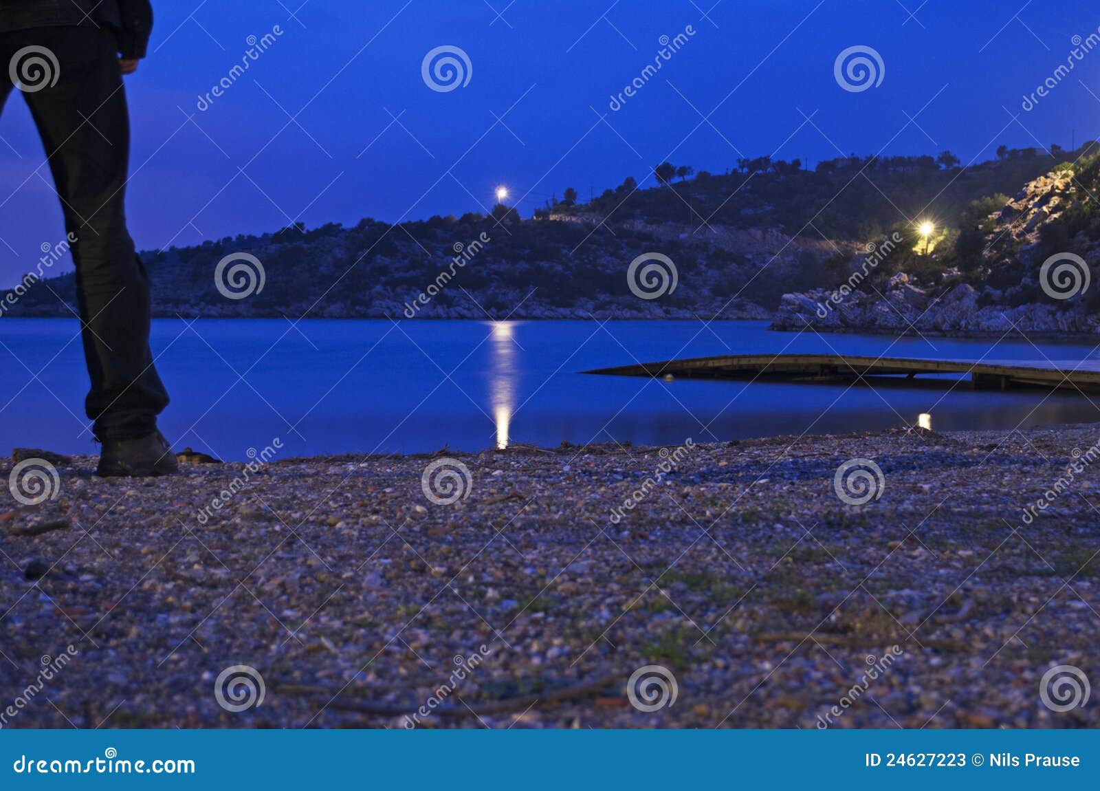 A Man Sitting on the Seawall at Night · Free Stock Photo