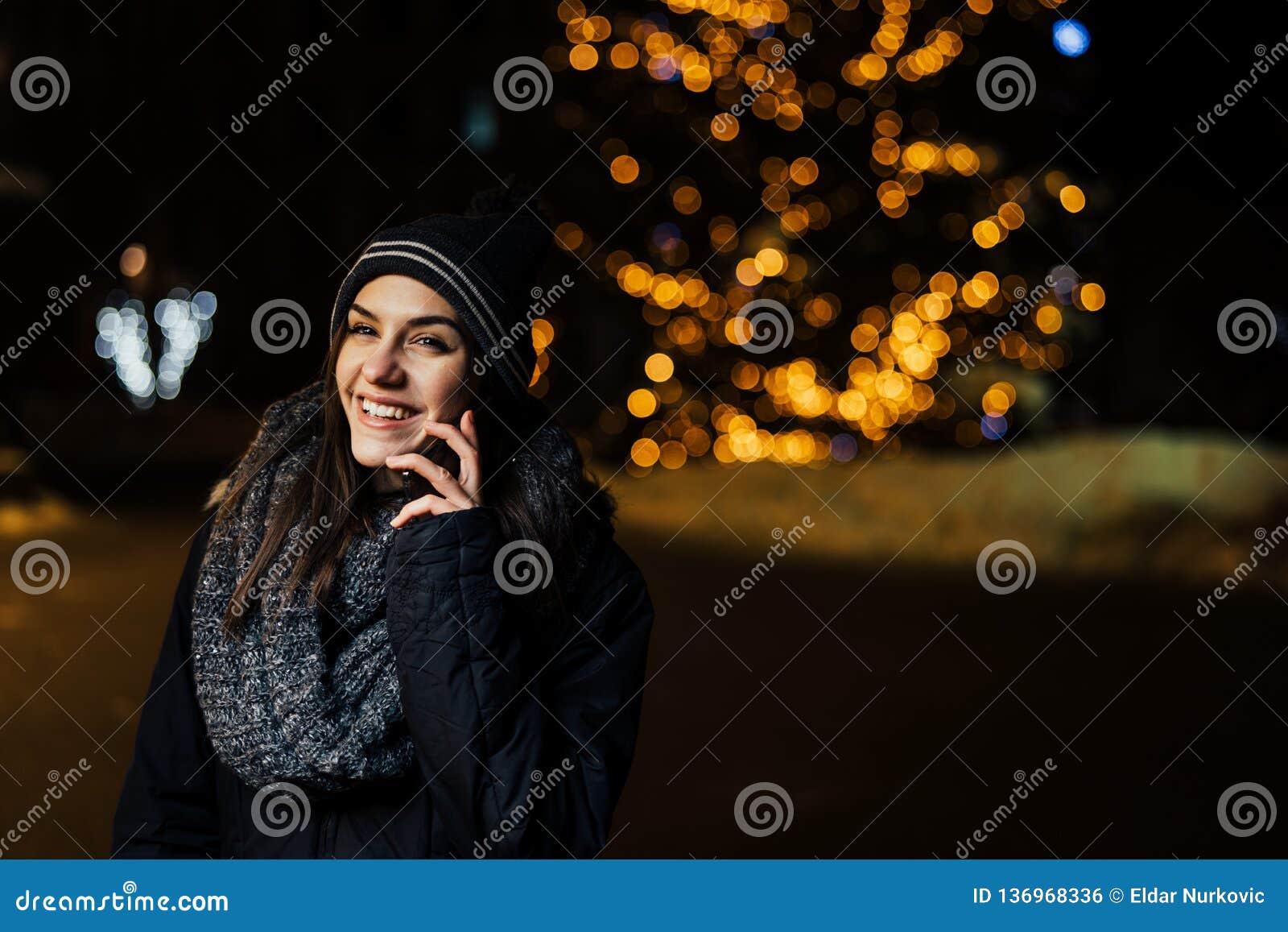 Night Portrait of a Beautiful Brunette Woman Using Smartphone during ...