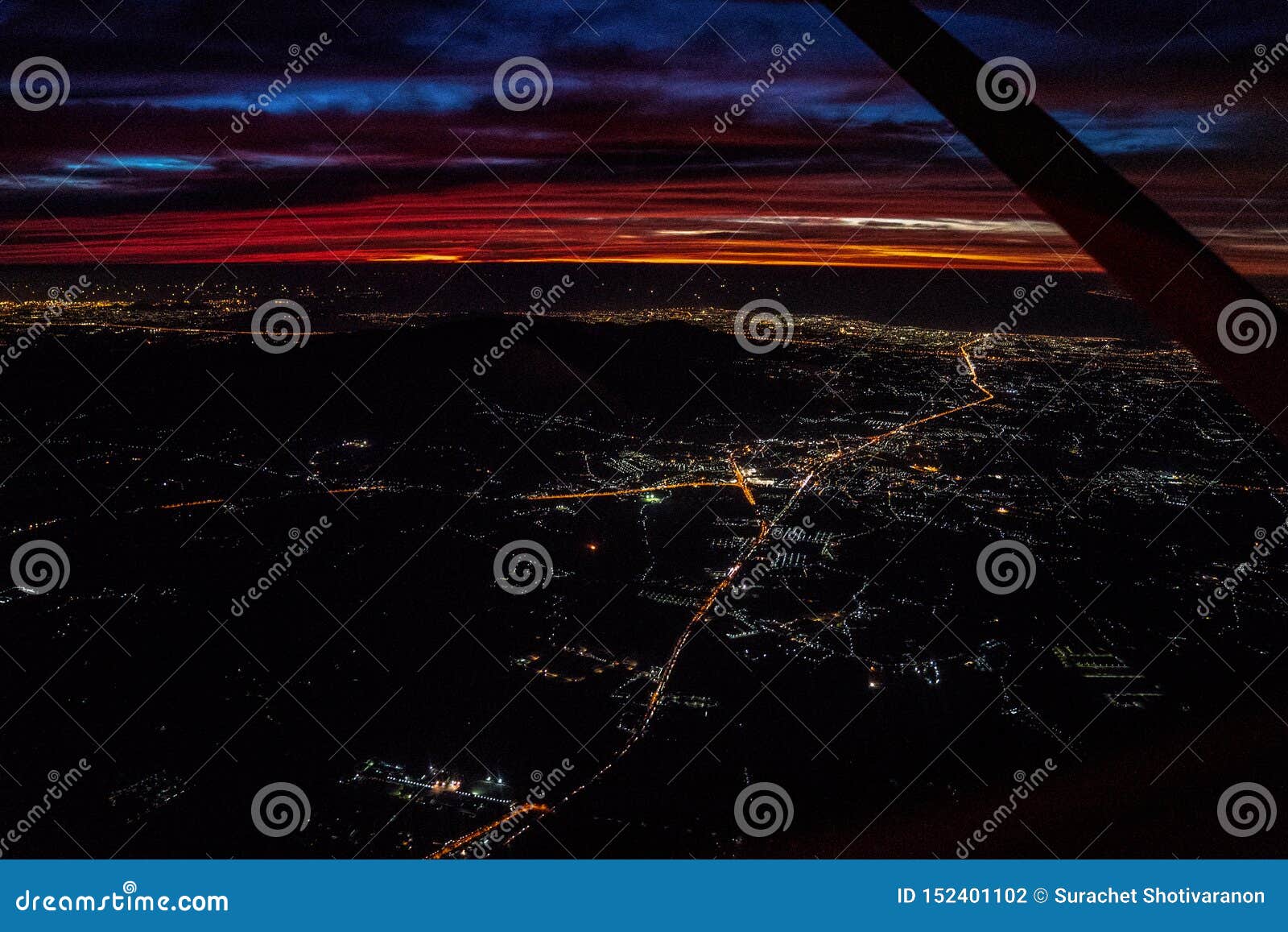 night view from the jetplane in twilight time with the red sky and light of the city