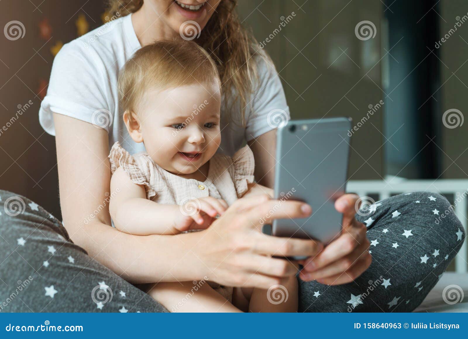 Nine-month-old Baby Girl Sits with Her Mother and Looks on Smartphone  Cartoons. Child is Talking To Her Grandmother Via Video Link Stock Image -  Image of gadget, cute: 158640963