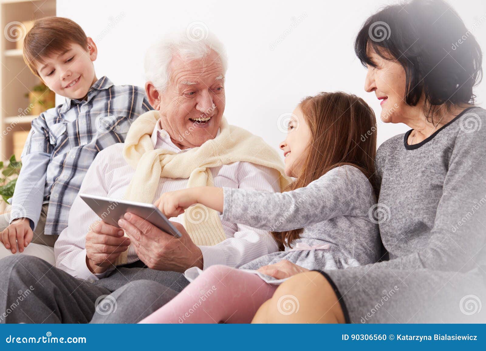 Nipoti Che Trattano Male I Nonni Nipoti E Nonni Che Per Mezzo Di Una Compressa Fotografia Stock