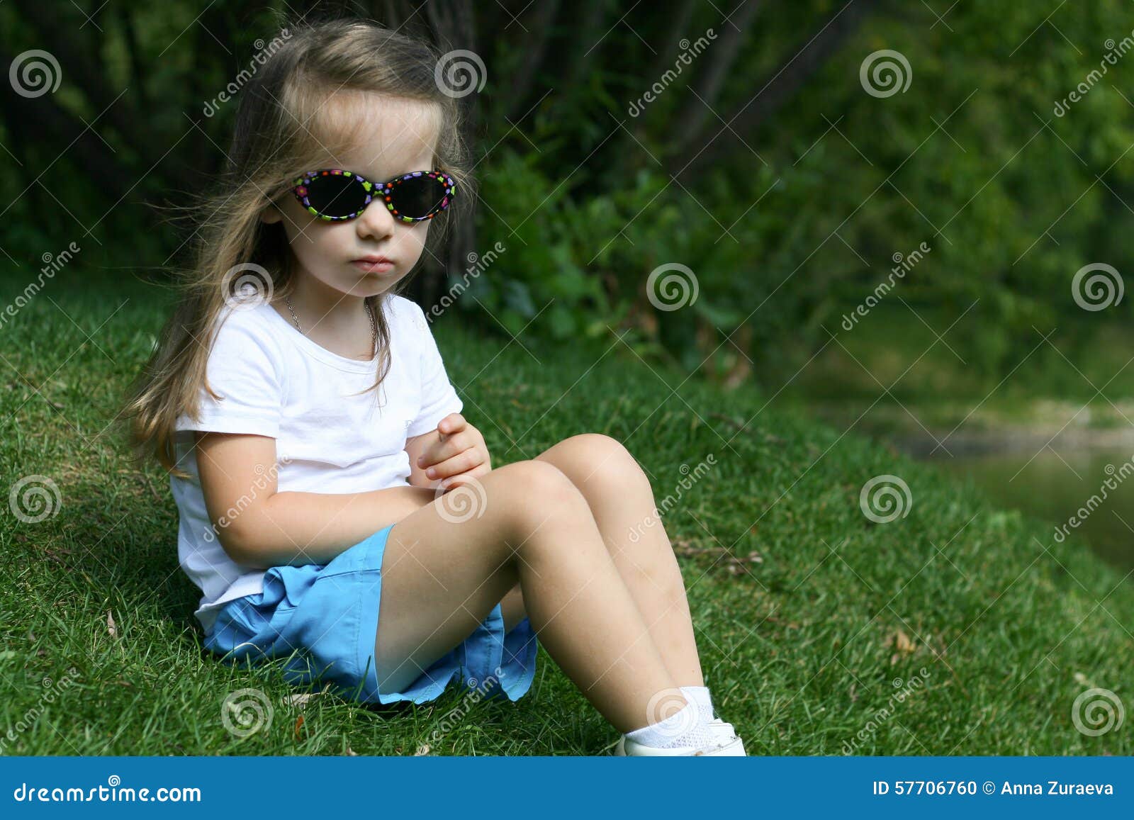 Niña adorable en un parque con los vidrios