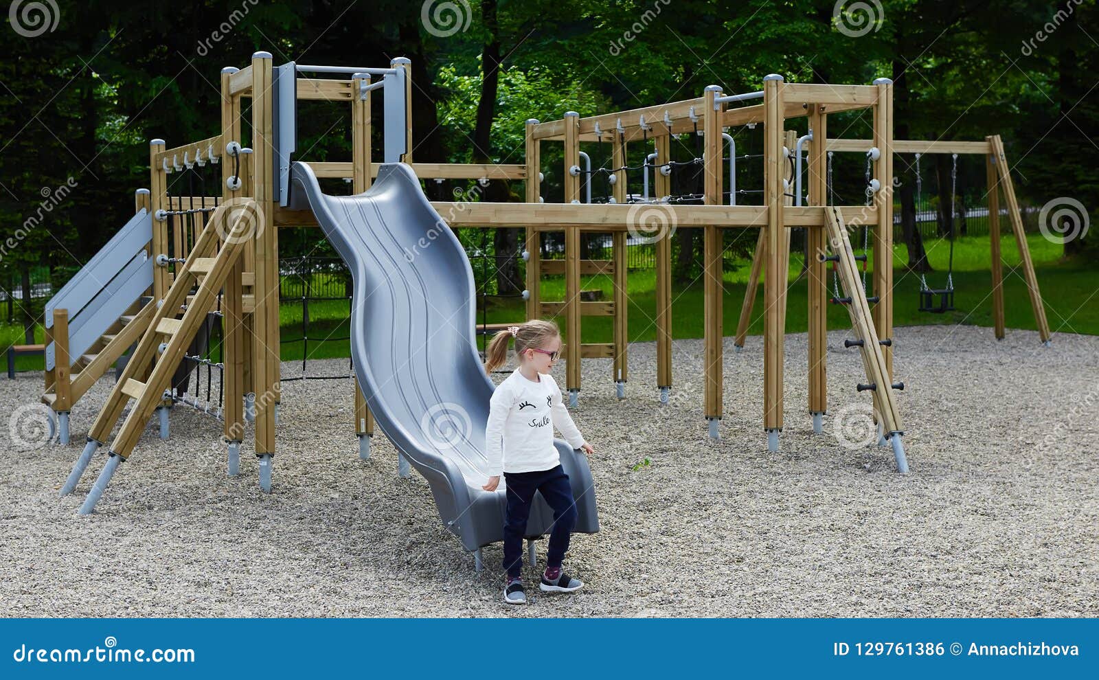 Niña en un patio Niño que juega al aire libre en verano Juego de los niños en patio de escuela Niño feliz en guardería o preescolar Niños que se divierten en el juego de la guardería molido Niño en una diapositiva