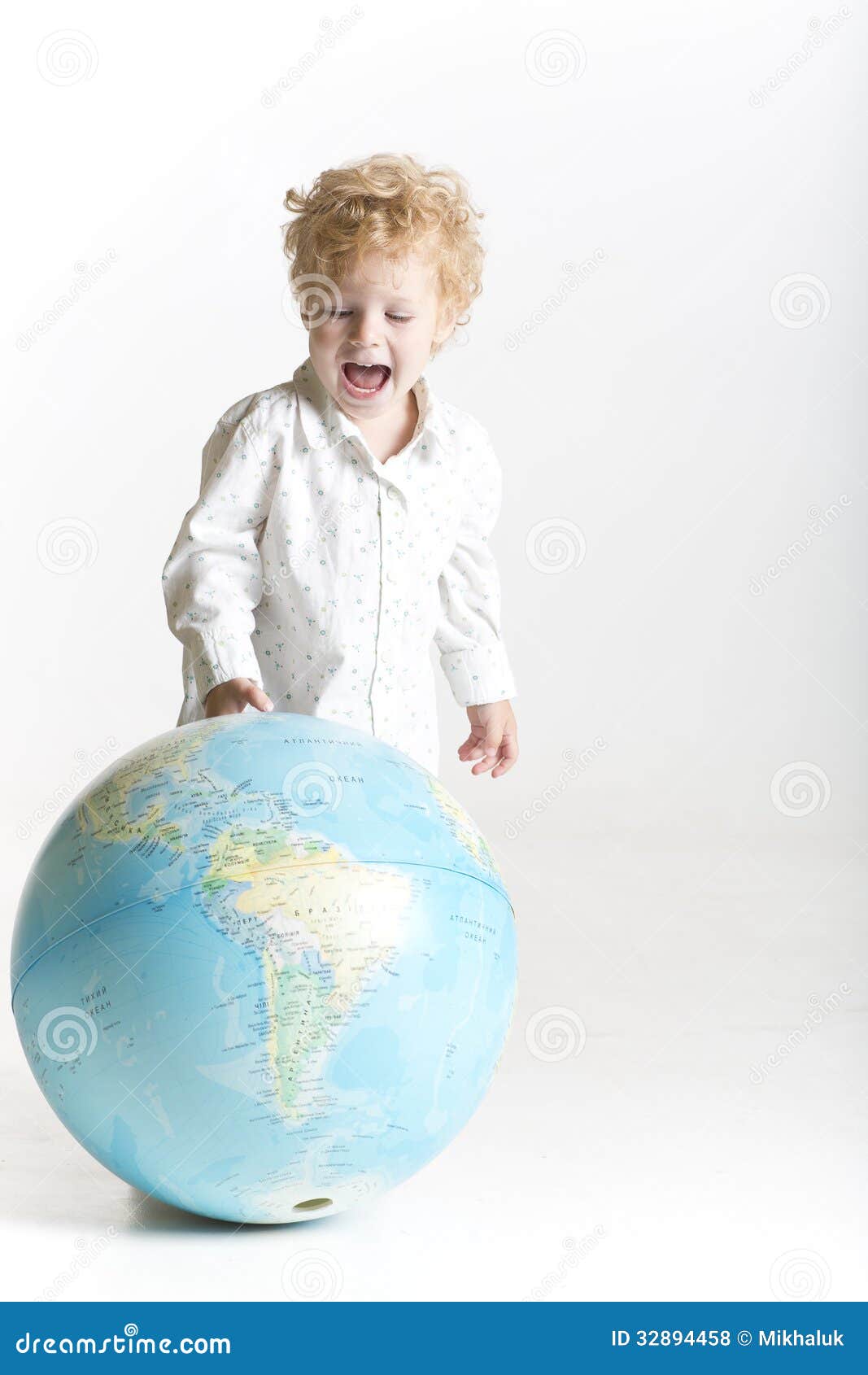 Niño emocionado con el mundo en su mano. Niño lindo con el globo aislado en blanco