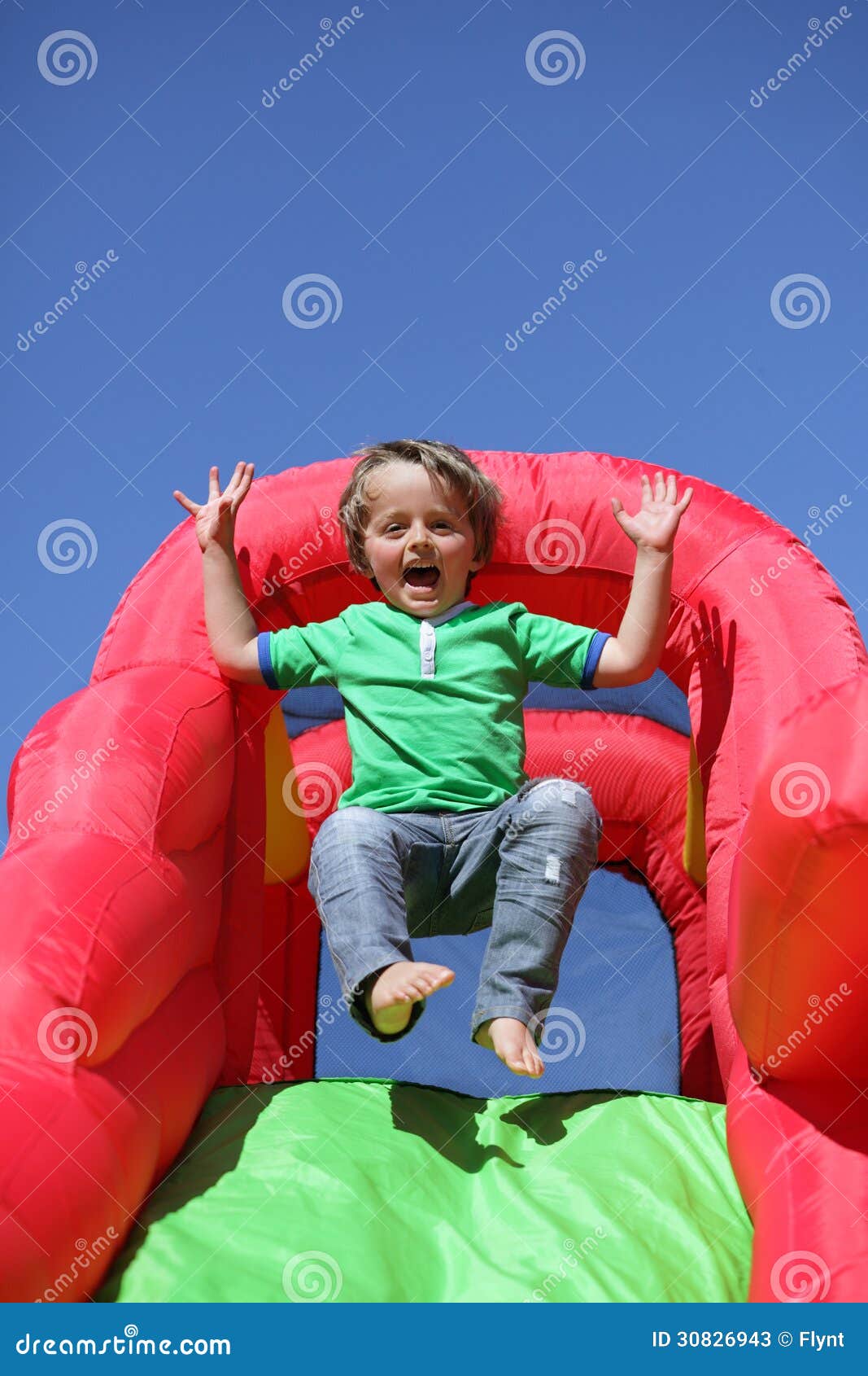 Niño En Diapositiva Animosa Inflable Del Castillo Imagen De Archivo